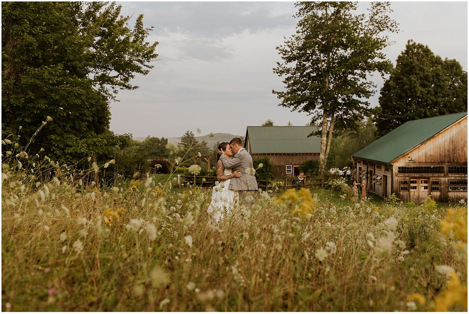 Panoramic view of a rustic farm venue with rolling fields and buildings in the distance.