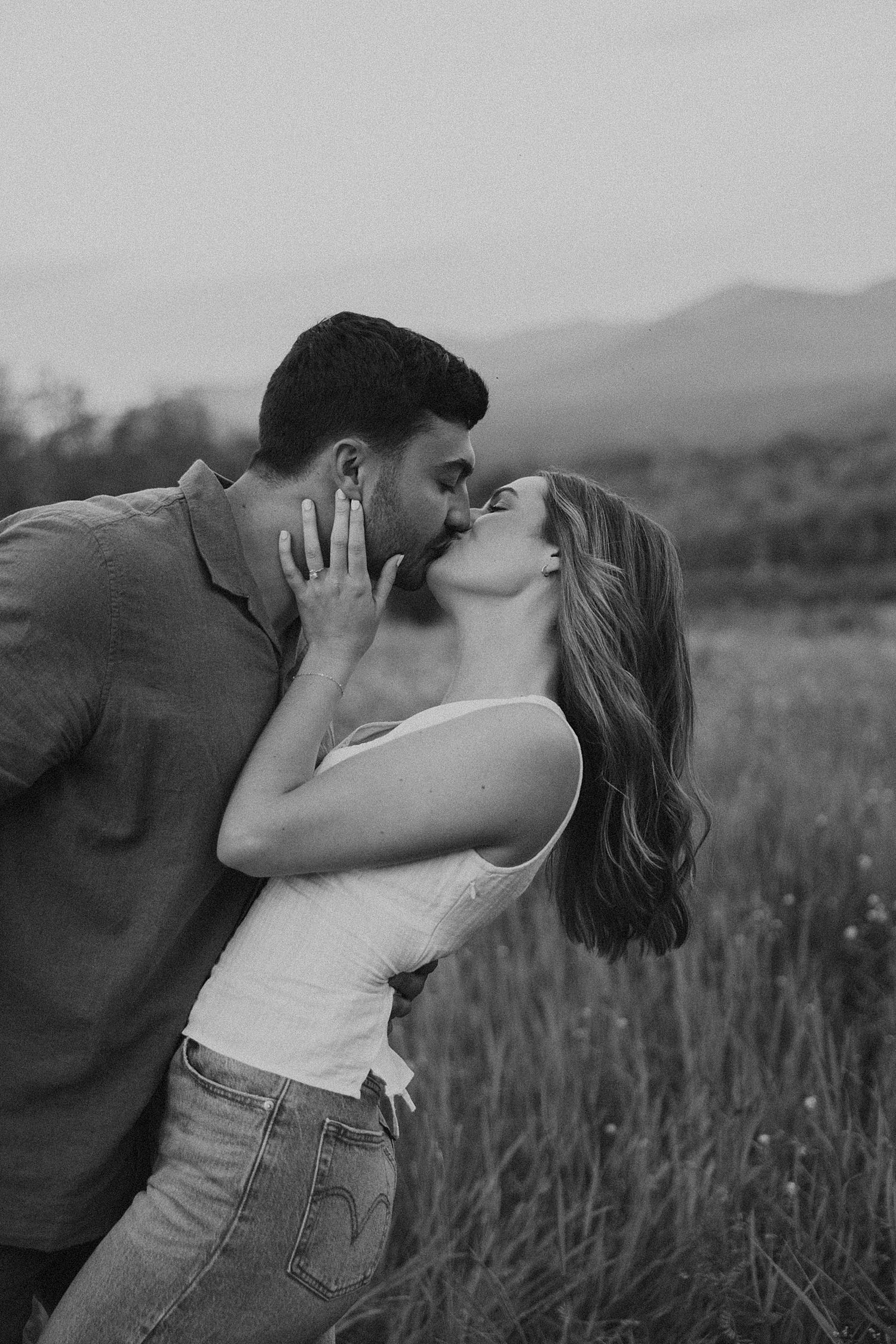 Black and white photo of a New Hampshire couple kissing during their golden hour engagement photo session