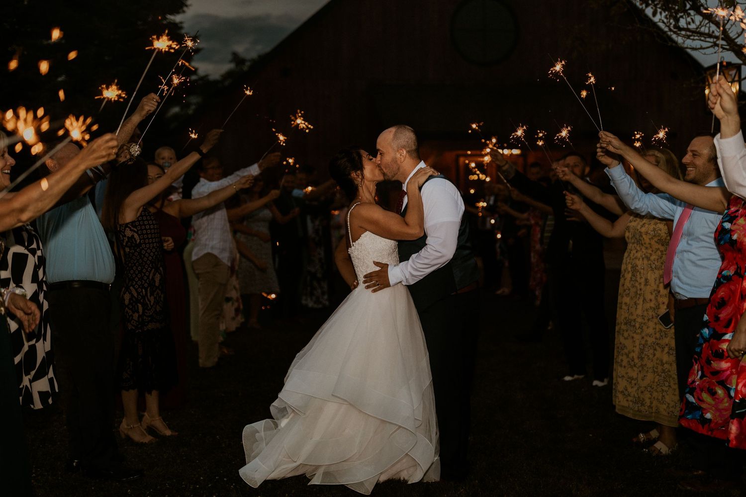 Guests dancing and celebrating at a dimly lit wedding reception.