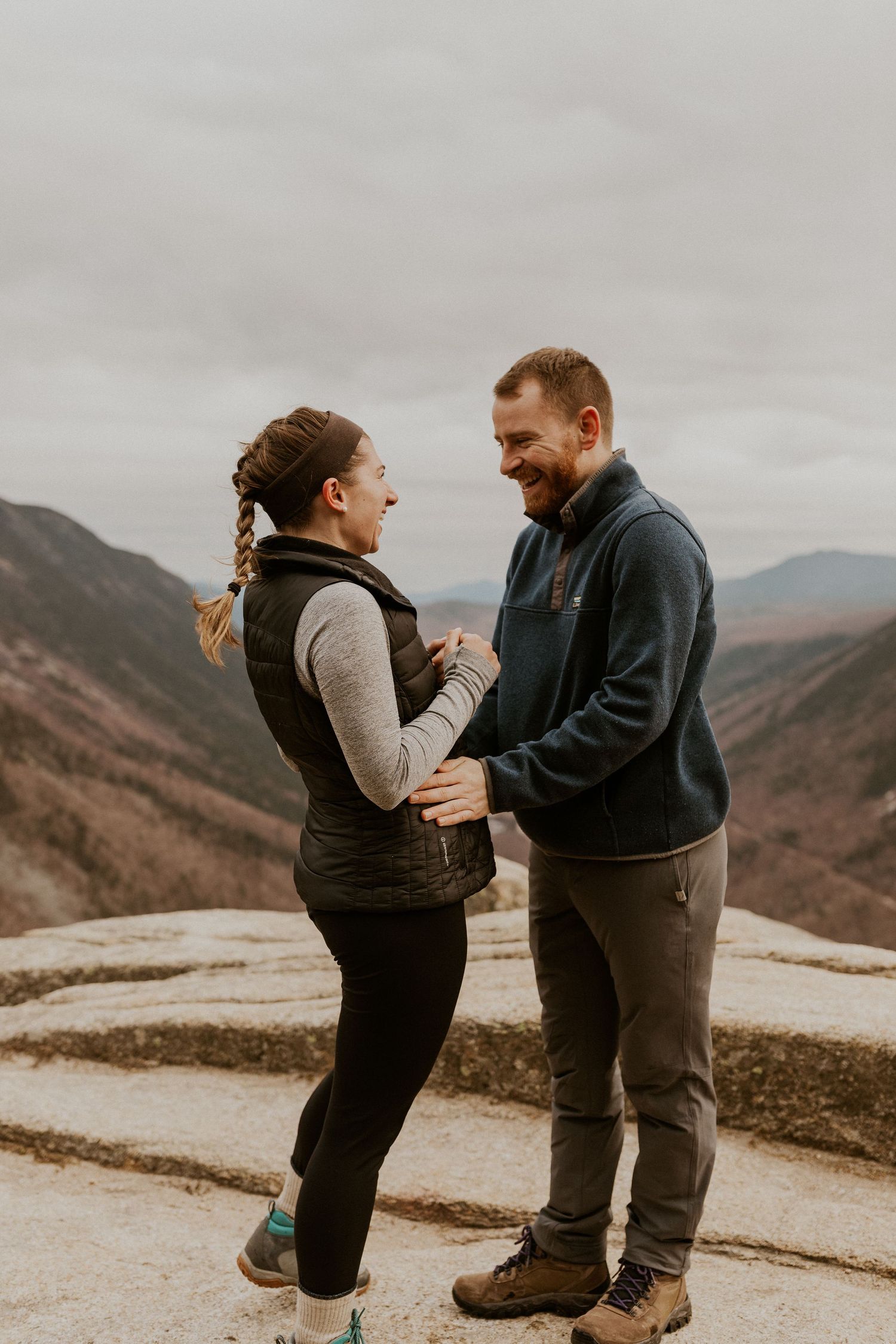 Newly engaged couple embracing each other on top of Mount Willard in the White Mountains of New Hampshire.