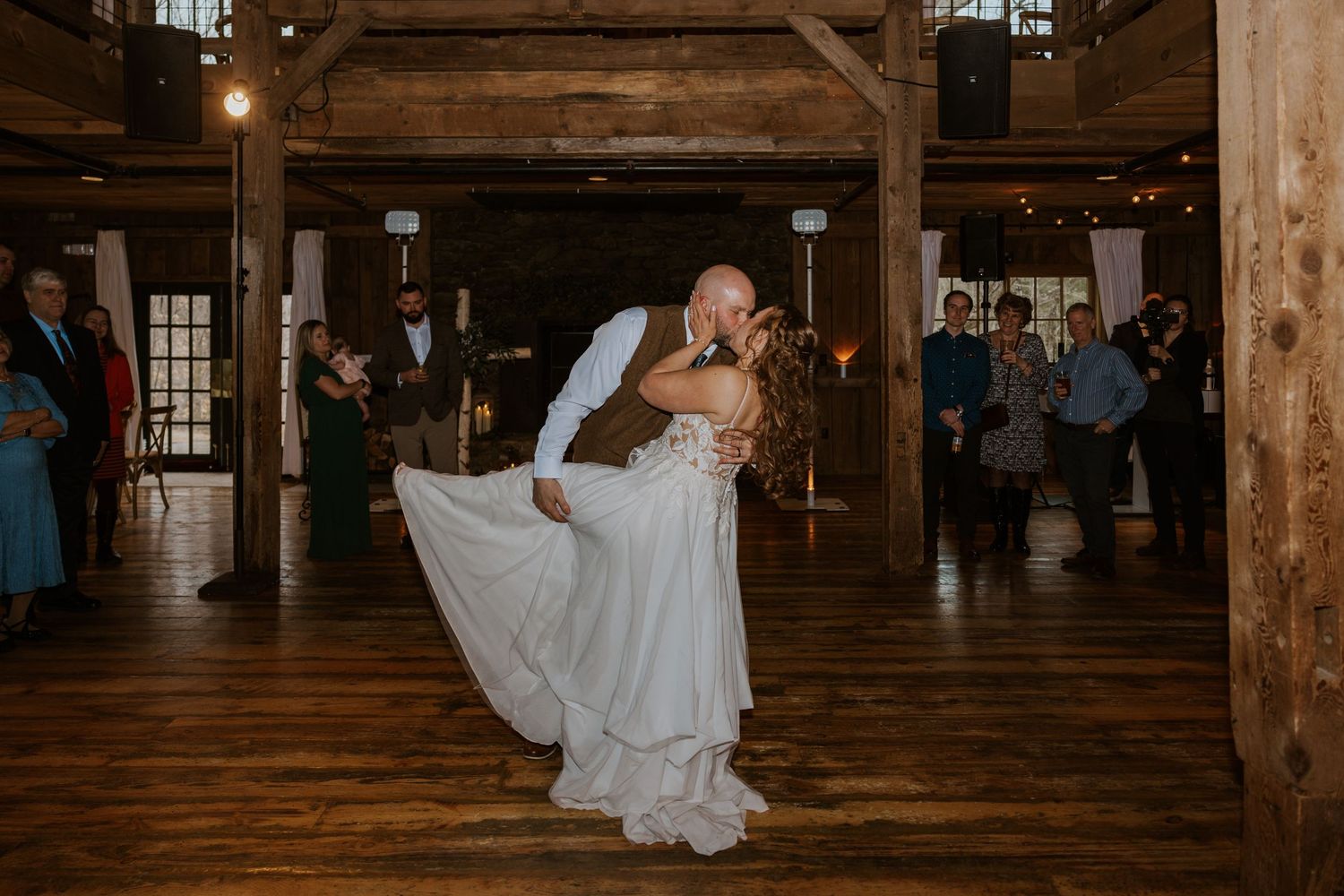 Dancing and celebration sequence inside a historic barn with exposed wooden beams.