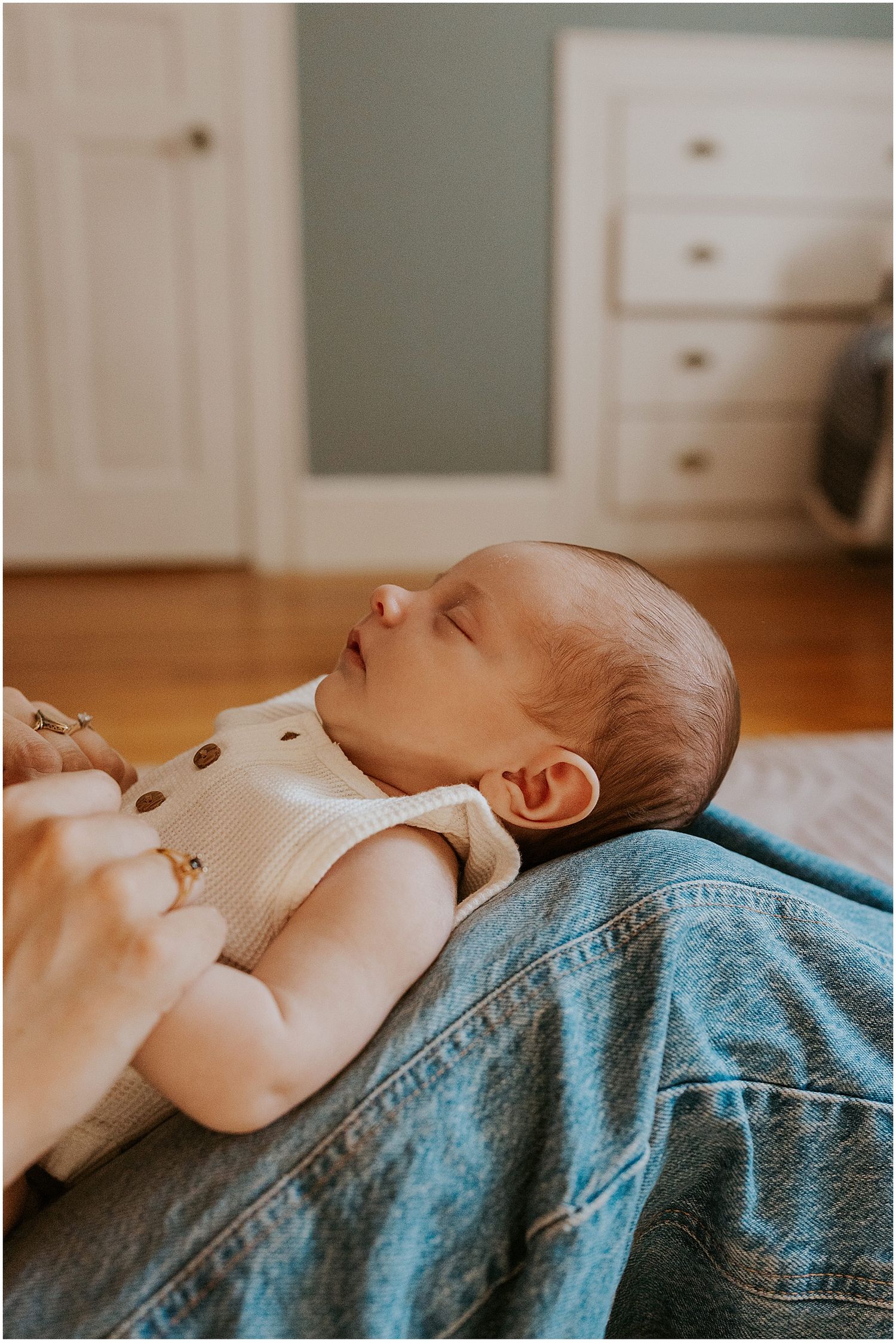 Newborn baby laying on mom's legs