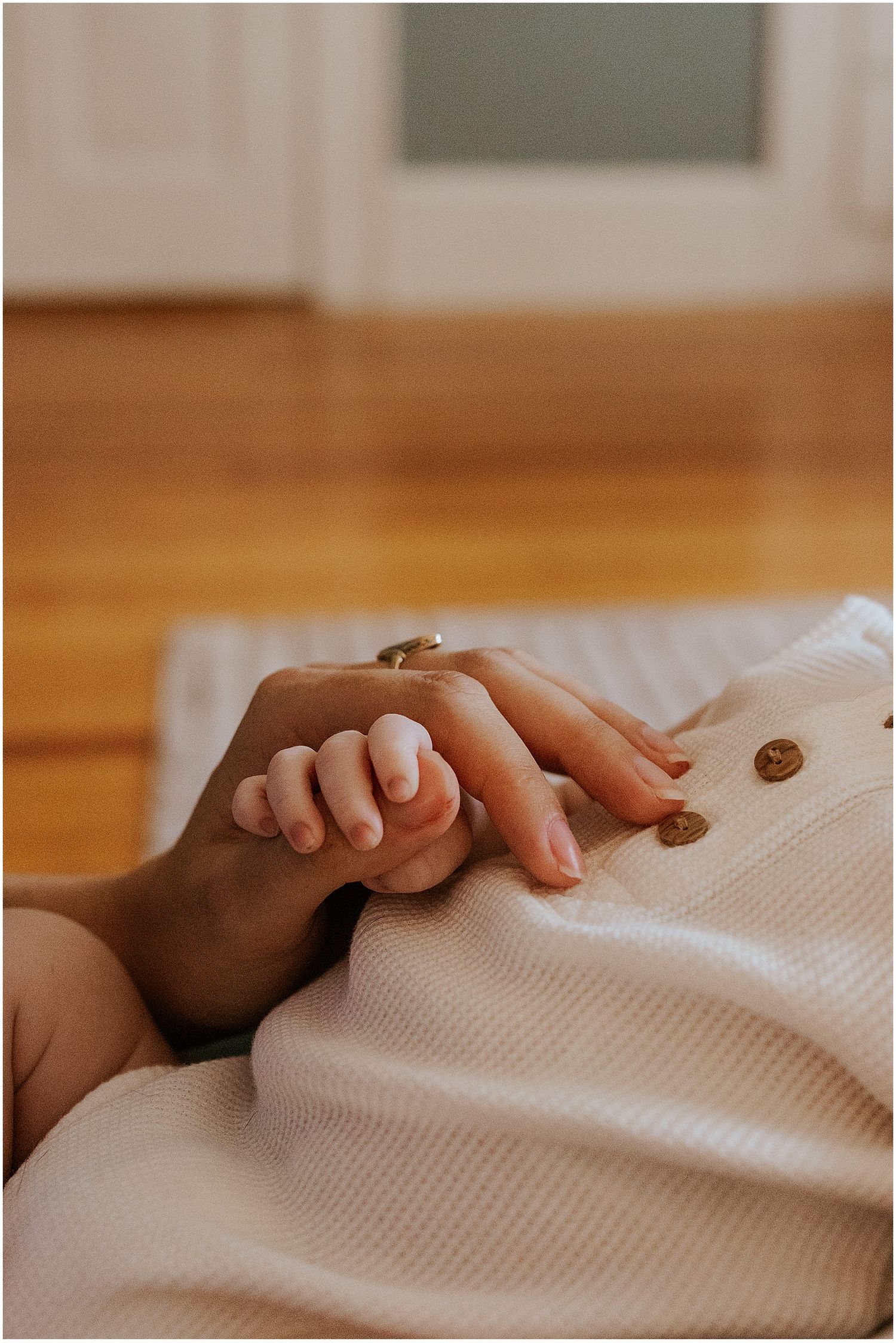 NH mom holding hands with her newborn baby