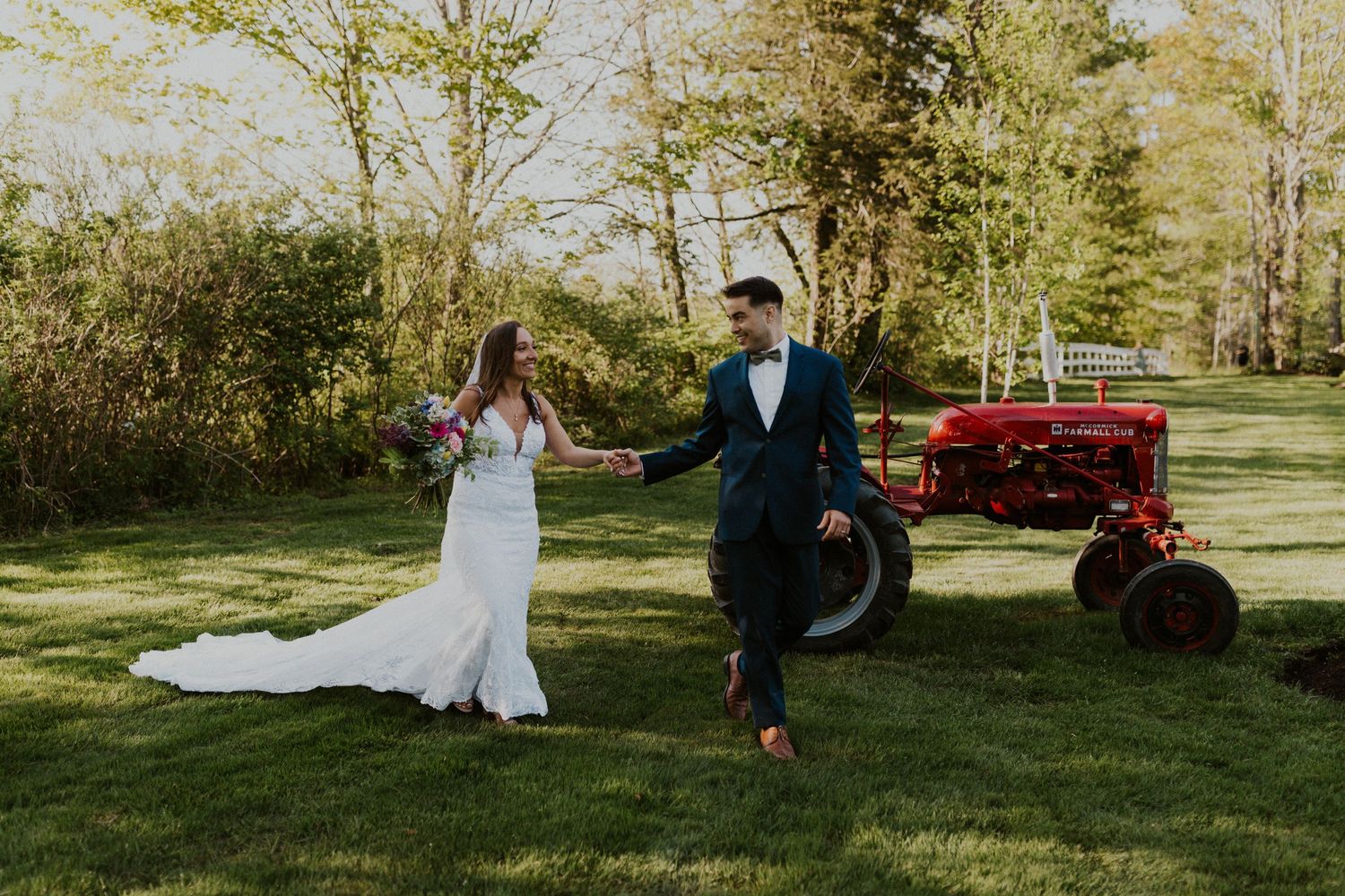 Mike leading Chrissy across the yard with the tractor in the background.