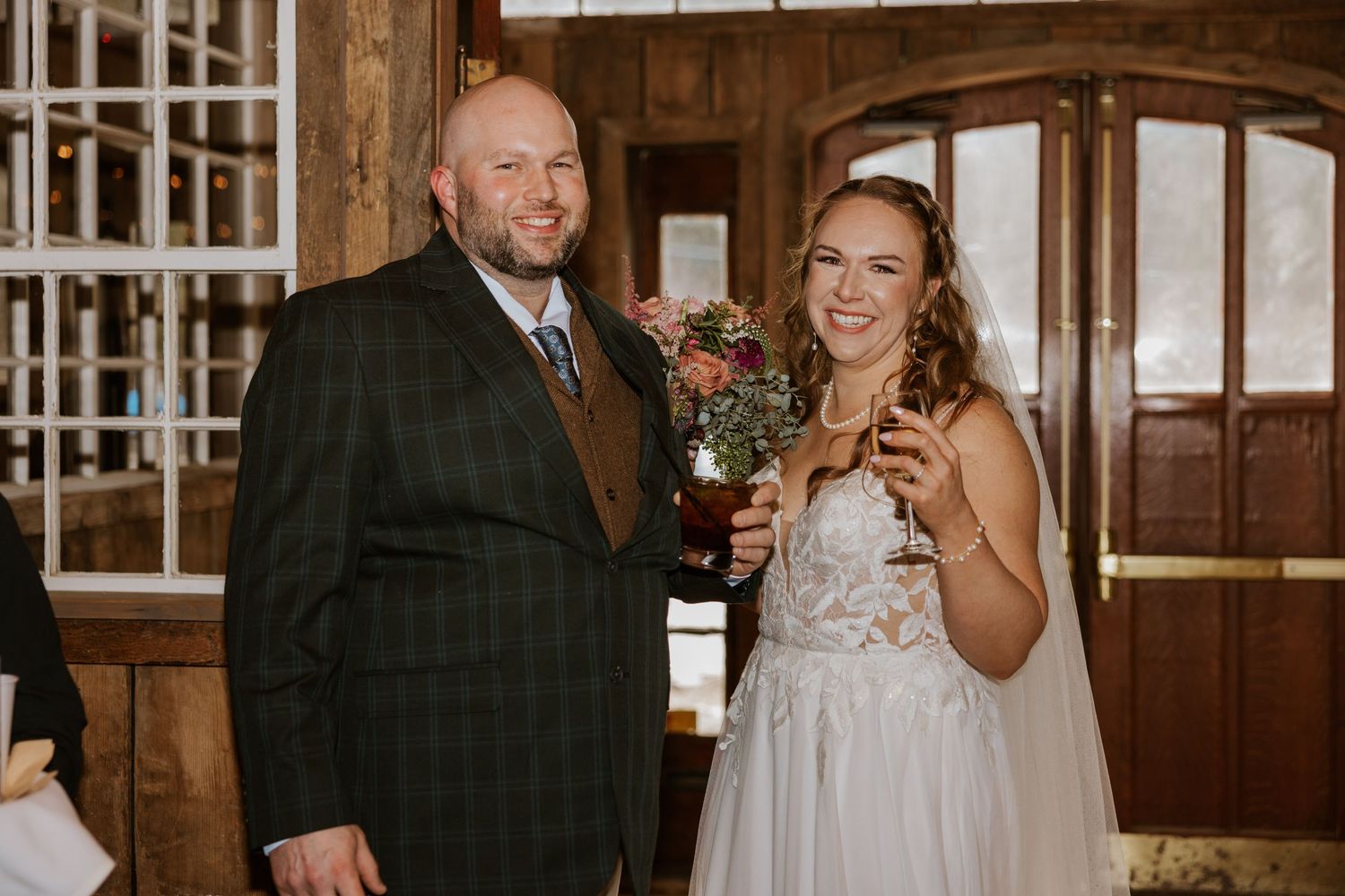 Candid wedding moments captured in a rustic barn venue with warm lighting and wooden beams.