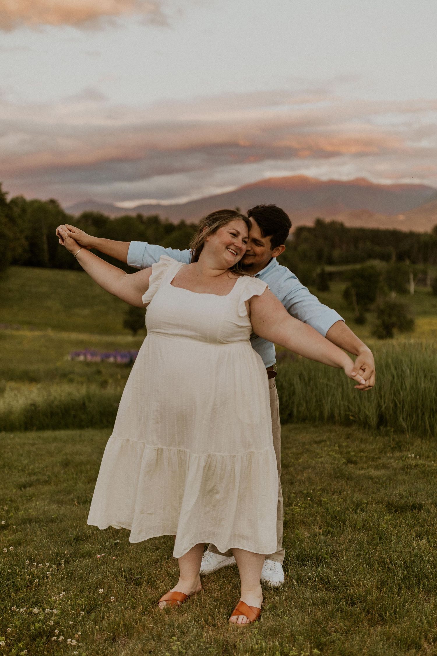 Terise and Jose playfully walking together in a lupine field in Sugar Hill NH during their engagement photos.