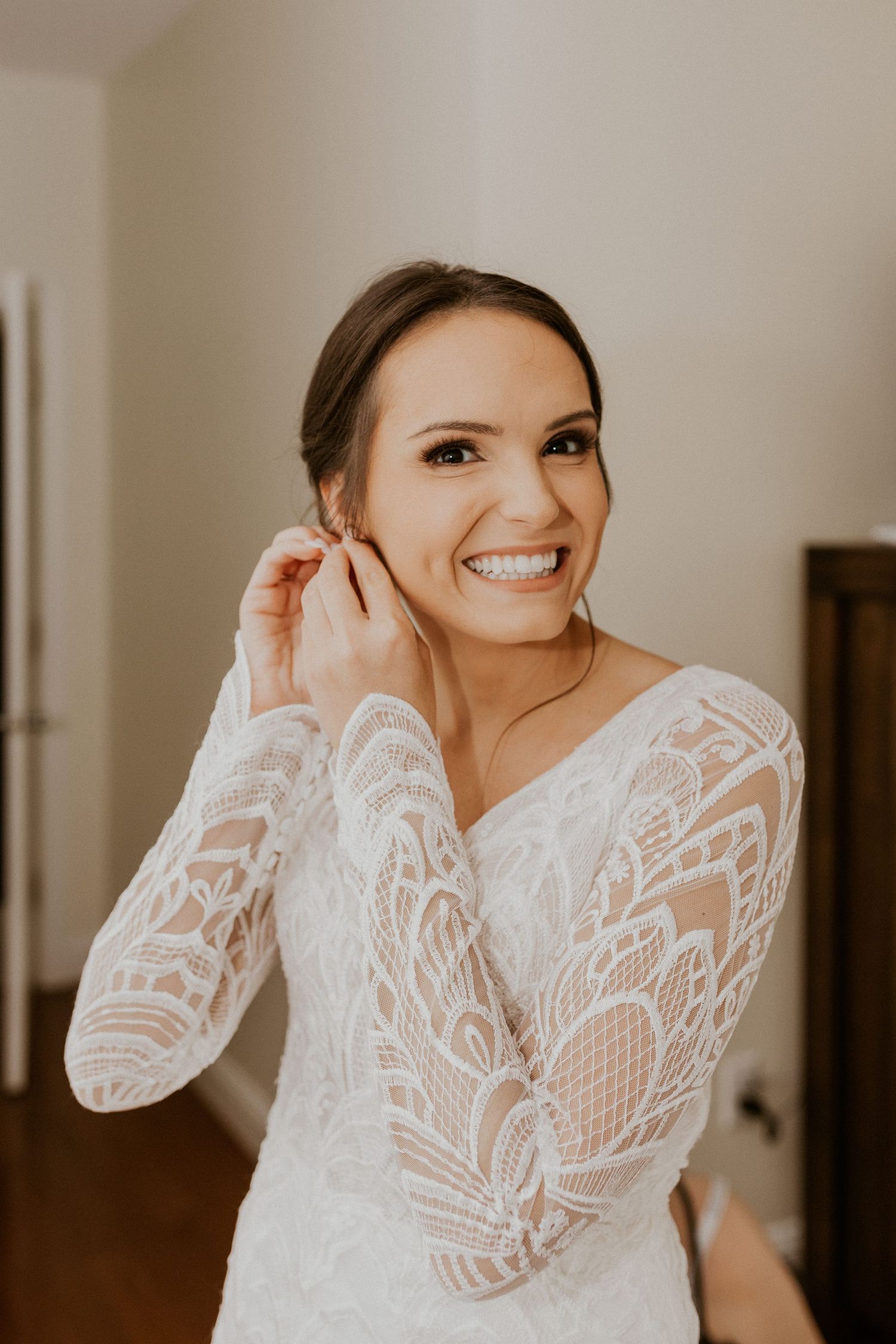 A photograph of the bride getting ready and putting her earrings in.