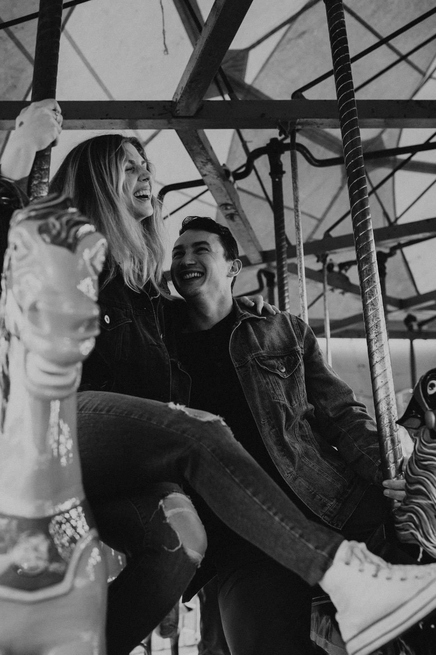 Couple enjoying a romantic moment on a vintage carousel at a carnival.