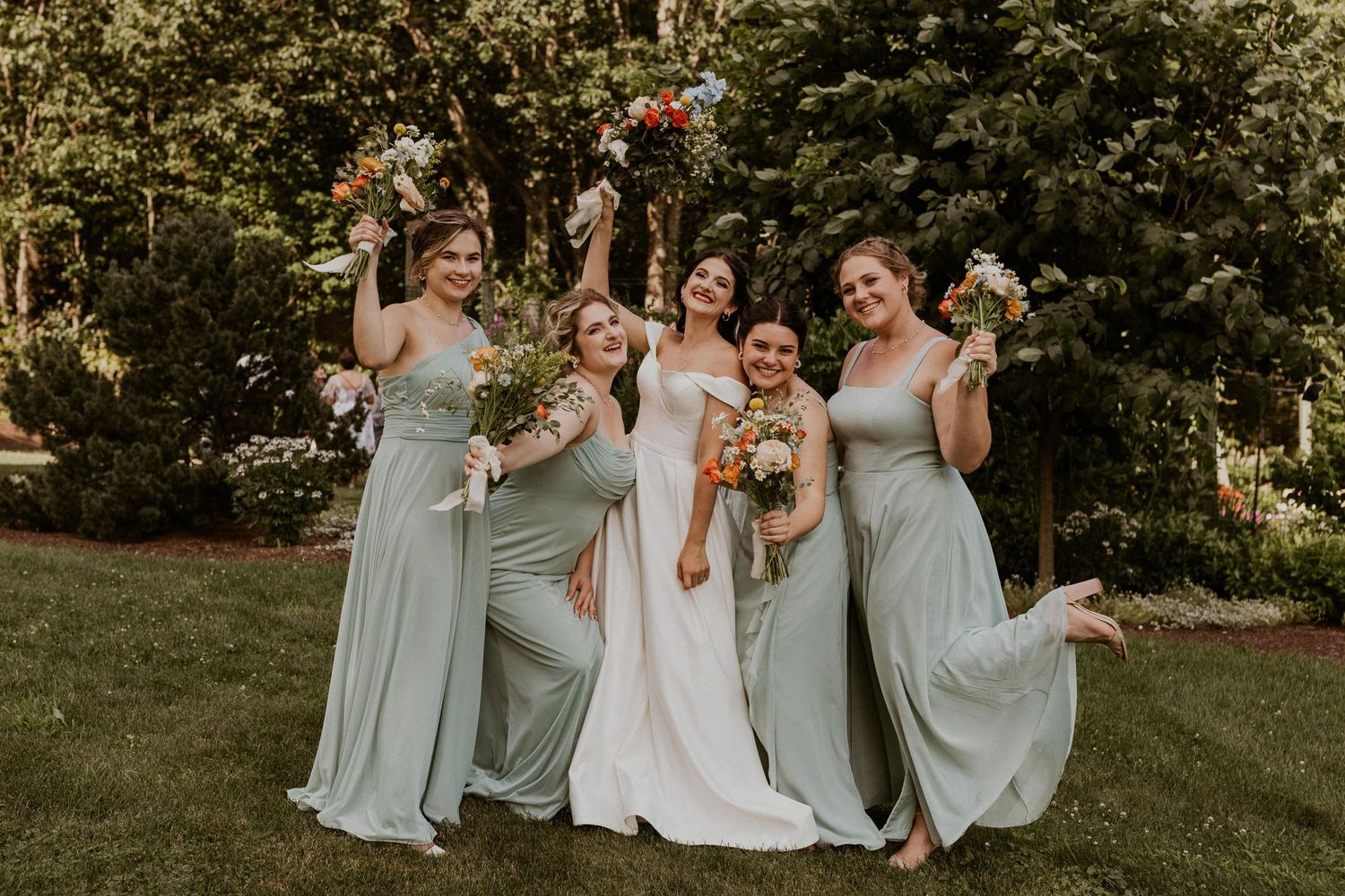 Outdoor wedding party group photo with bridesmaids in light blue dresses.
