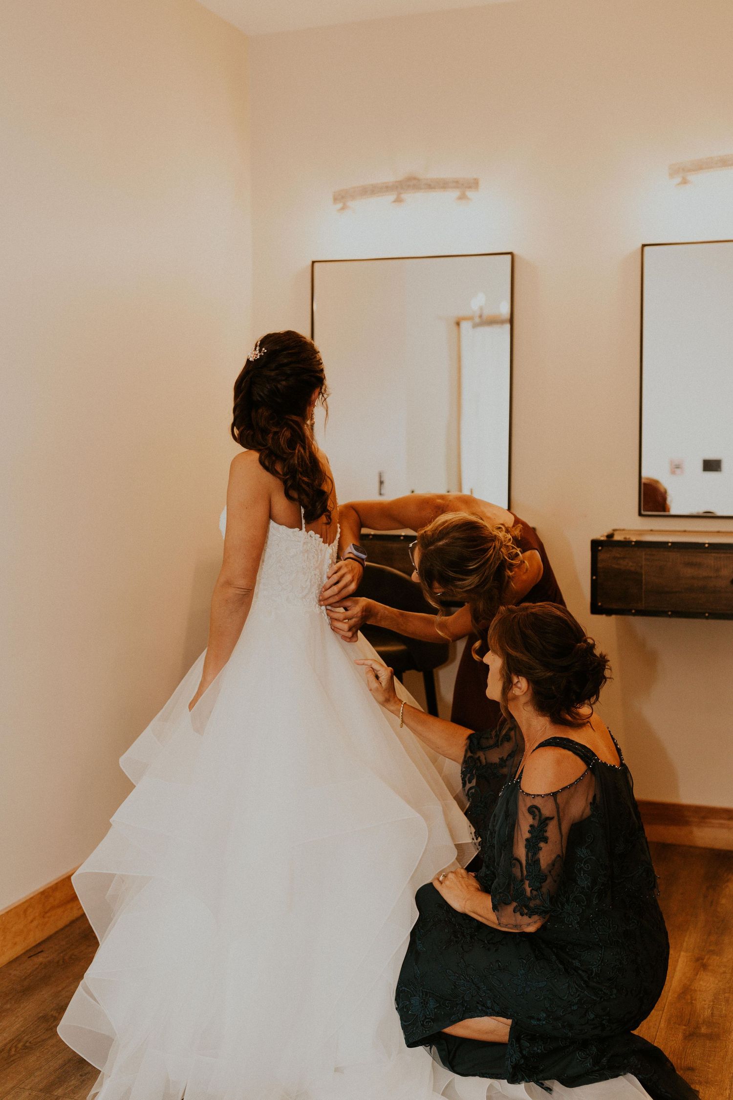 Jessica's mother and cousin helping her put on and zip her dress.