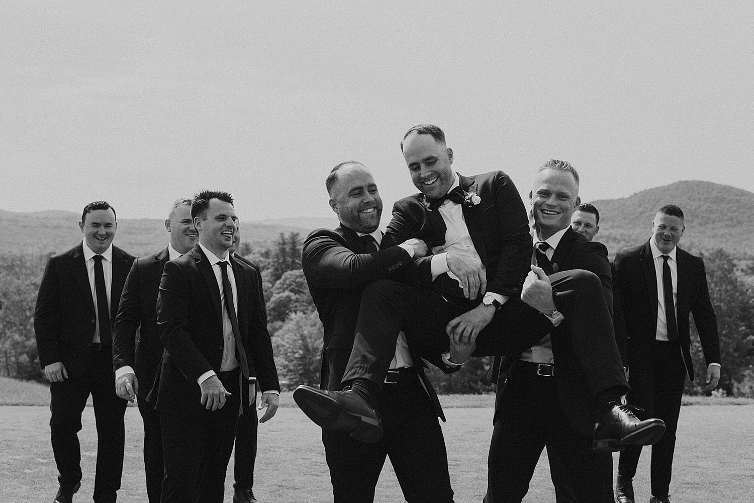Groom and his groomsmen taking portraits at a New Hampshire wedding