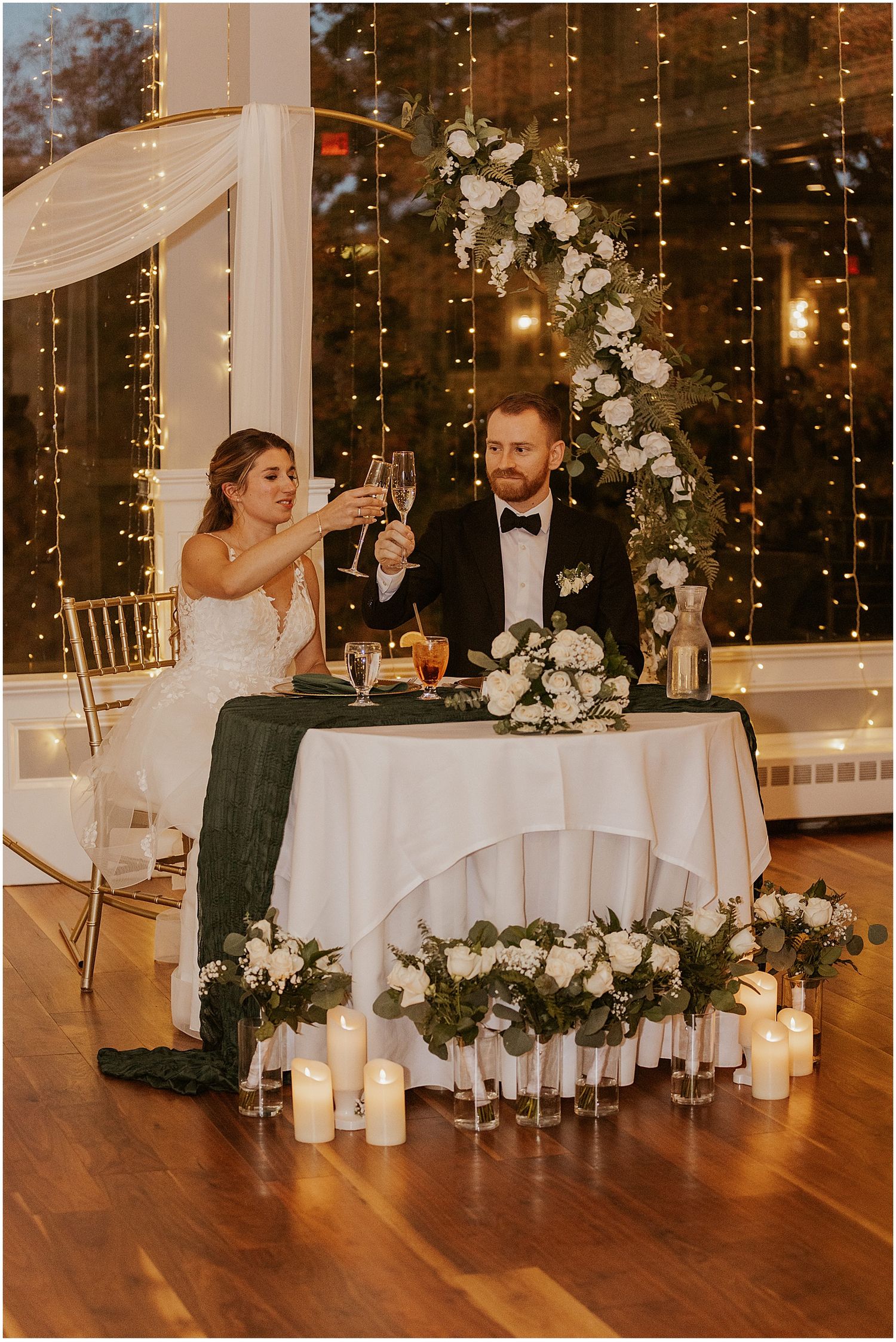 Wedding sweetheart table decorated with white flowers and candles.