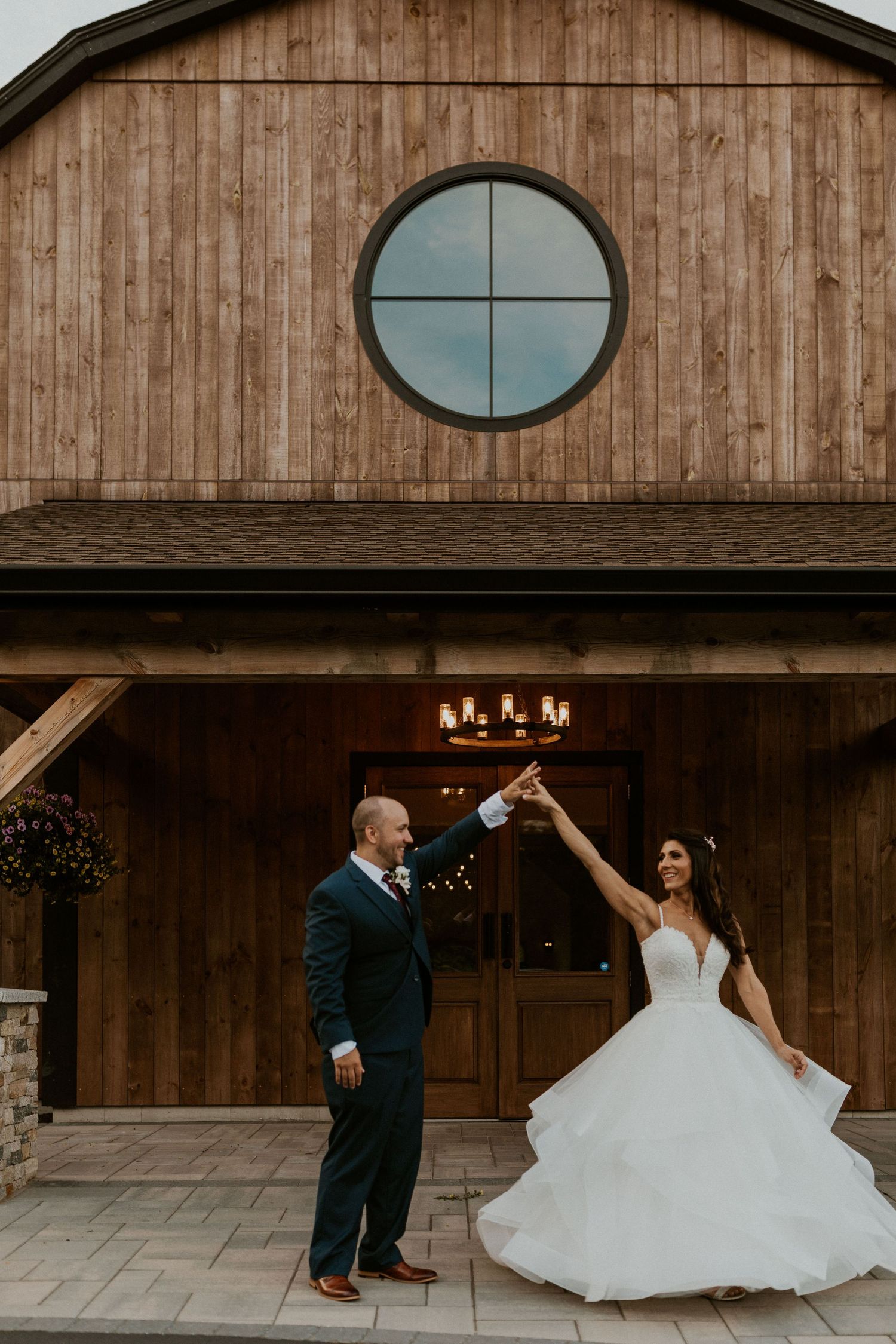 Modern barn wedding venue exterior with circular windows and wooden siding.