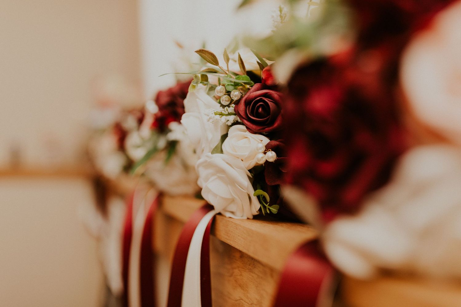 A detail photo of the bridesmaid bouquets. The bouquets are made of white and red silk roses.