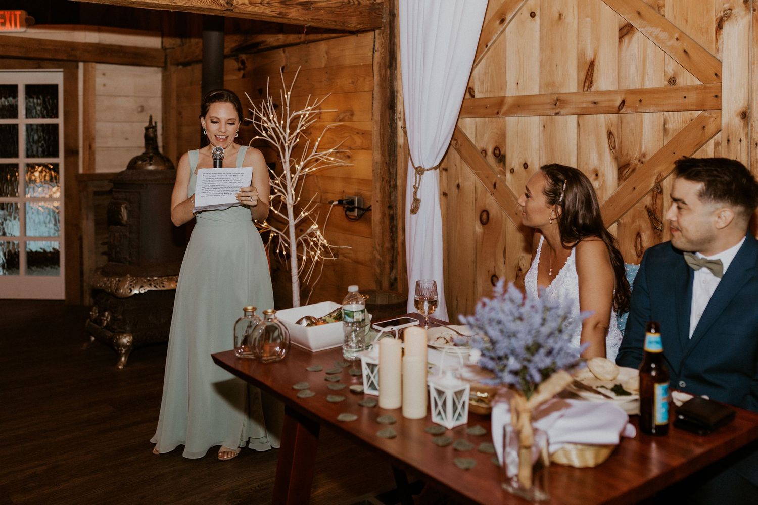 Rustic barn wedding venue with wooden beams and white drapery creating an elegant atmosphere.