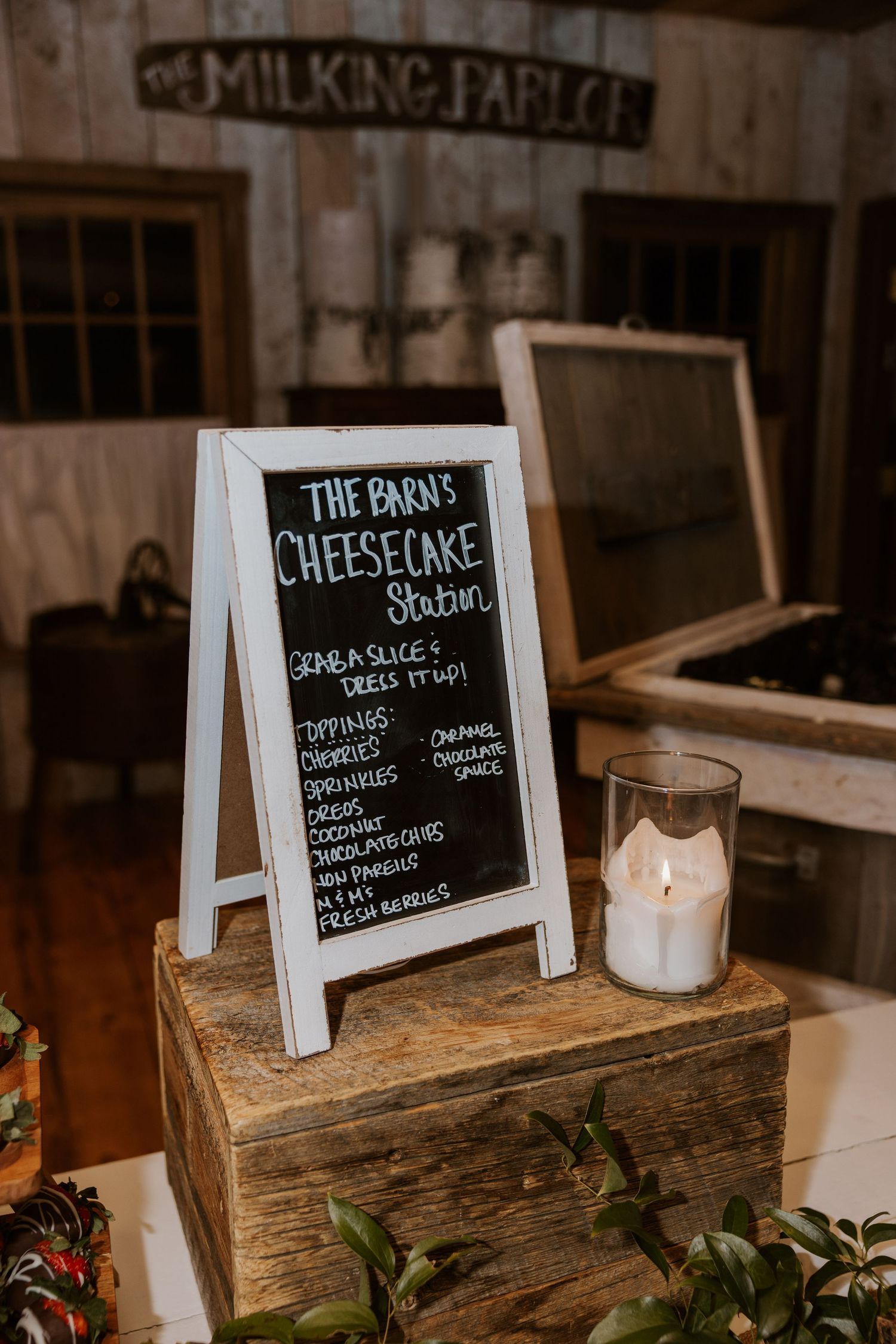 Chalkboard menu signs displaying cheesecake options on rustic wooden tables with candle decorations.