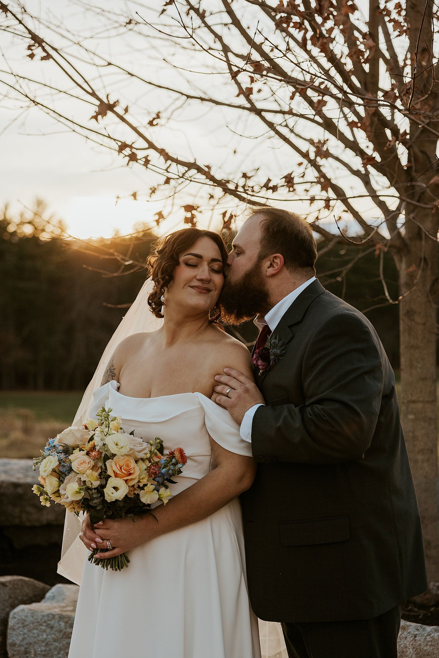 Bride and groom taking romantic sunset portraits at their New Hampshire wedding