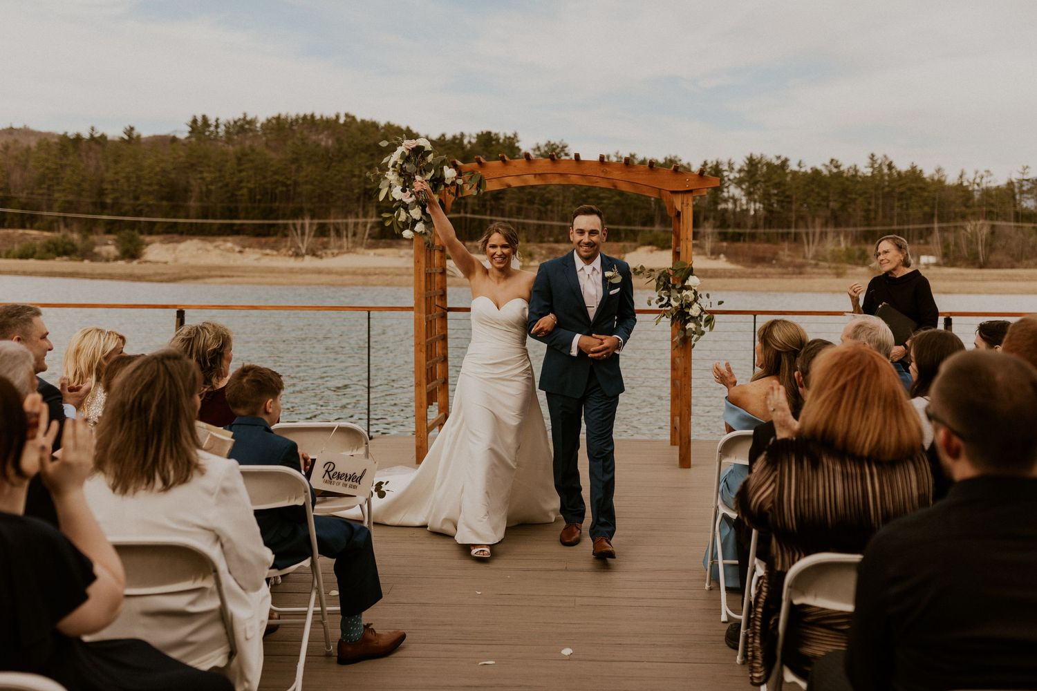 Kendra and Andrew celebrating as they walk back up the aisle to exit their wedding ceremony.