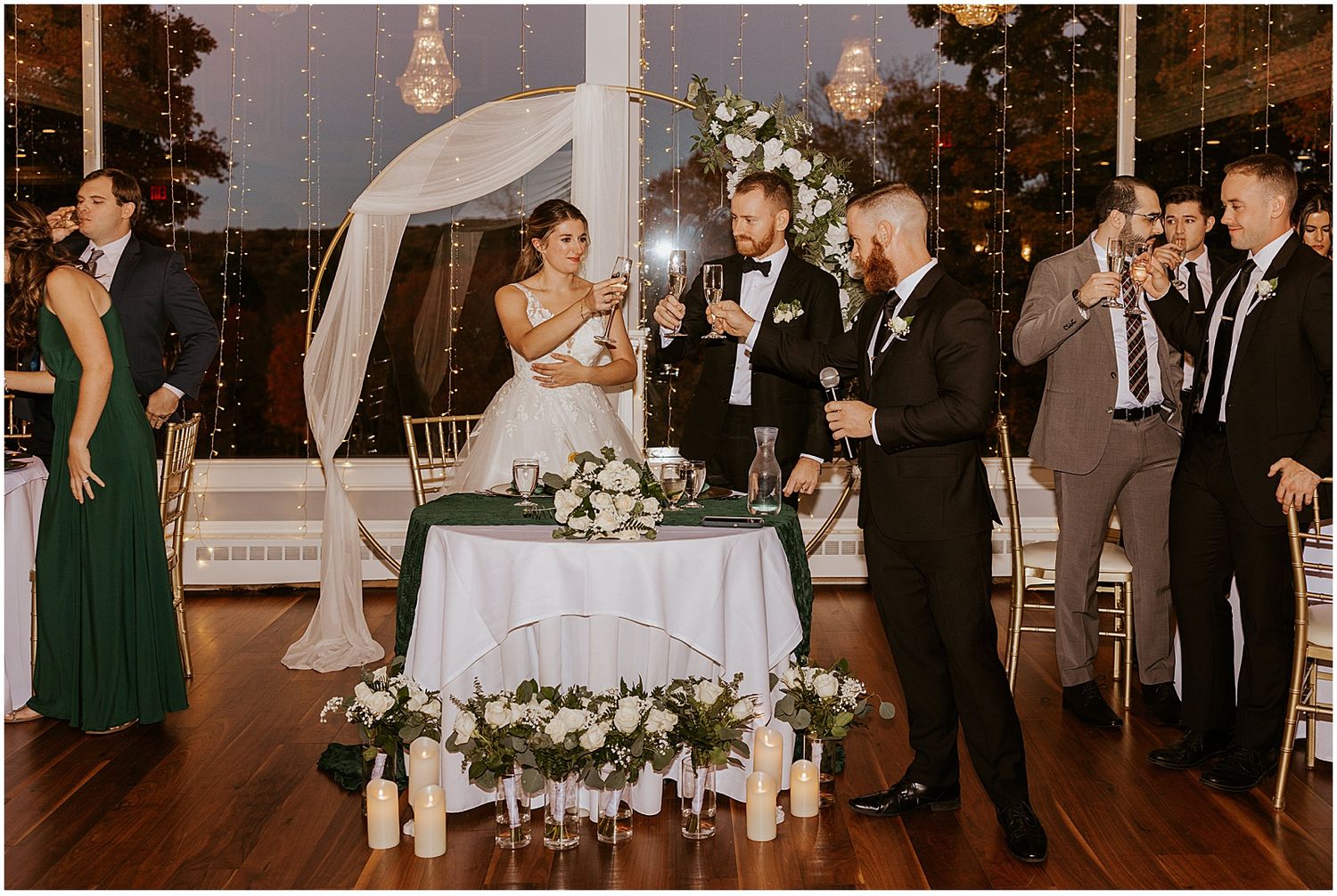 Wedding reception venue with elegant lighting and white floral decorations.