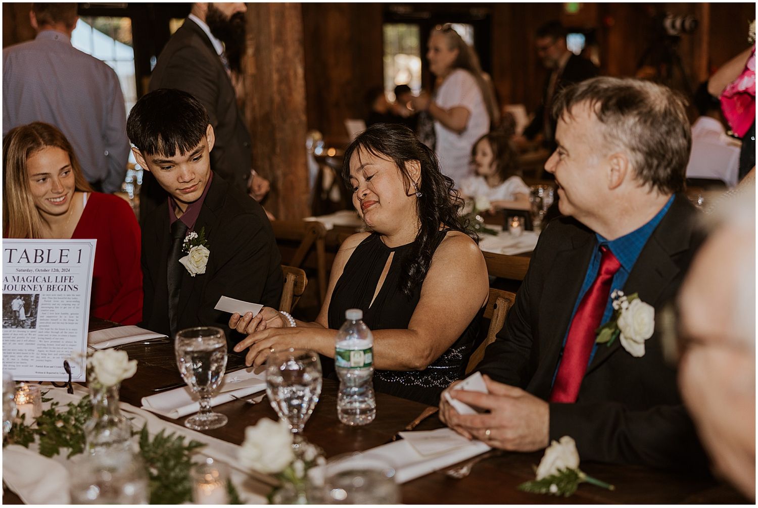 Wedding guests seated at long tables during an indoor reception.
