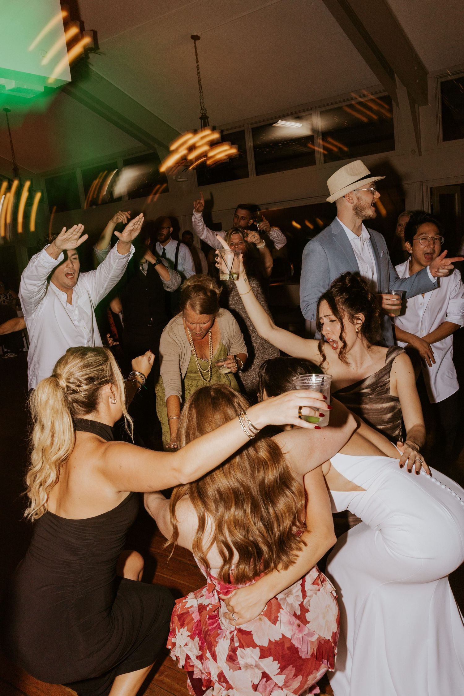 Bride and guests dancing and celebrating on lively wedding reception dance floor.