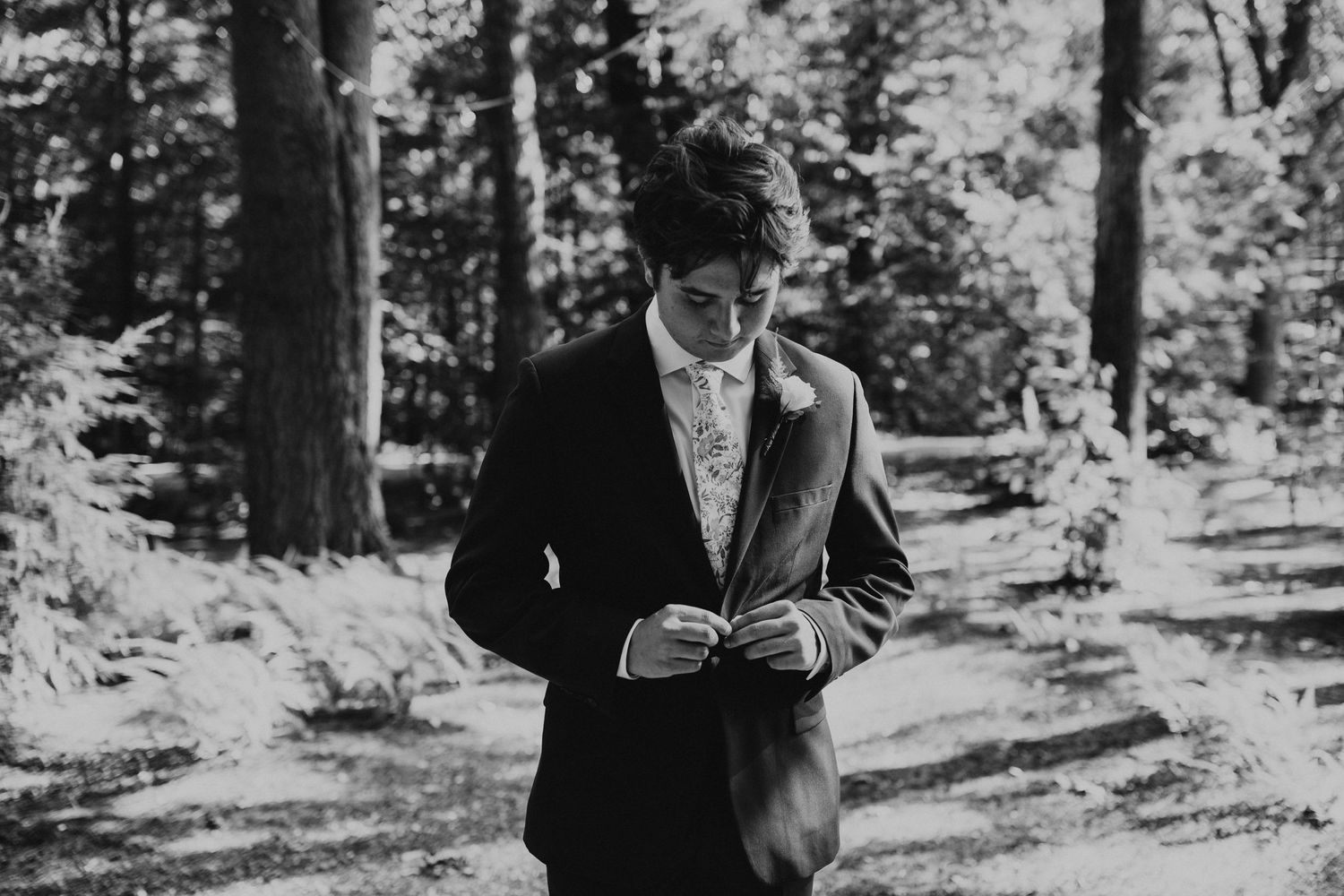 A couple shares an intimate moment during their wedding ceremony in a serene wooded setting.