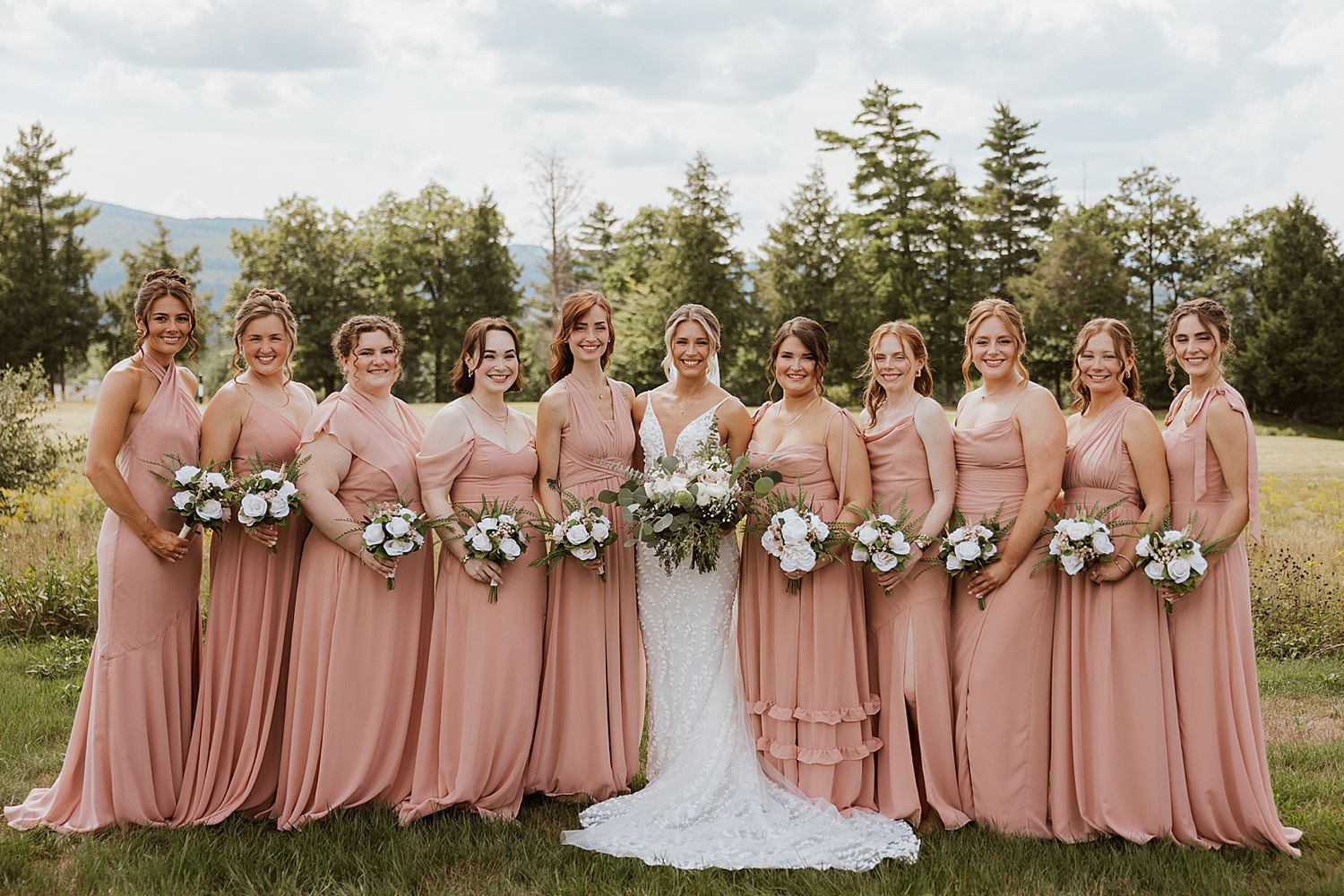 Bride and bridesmaids posing for portraits outside the Sunset Pavilion at the Owl's Nest Resort in NH
