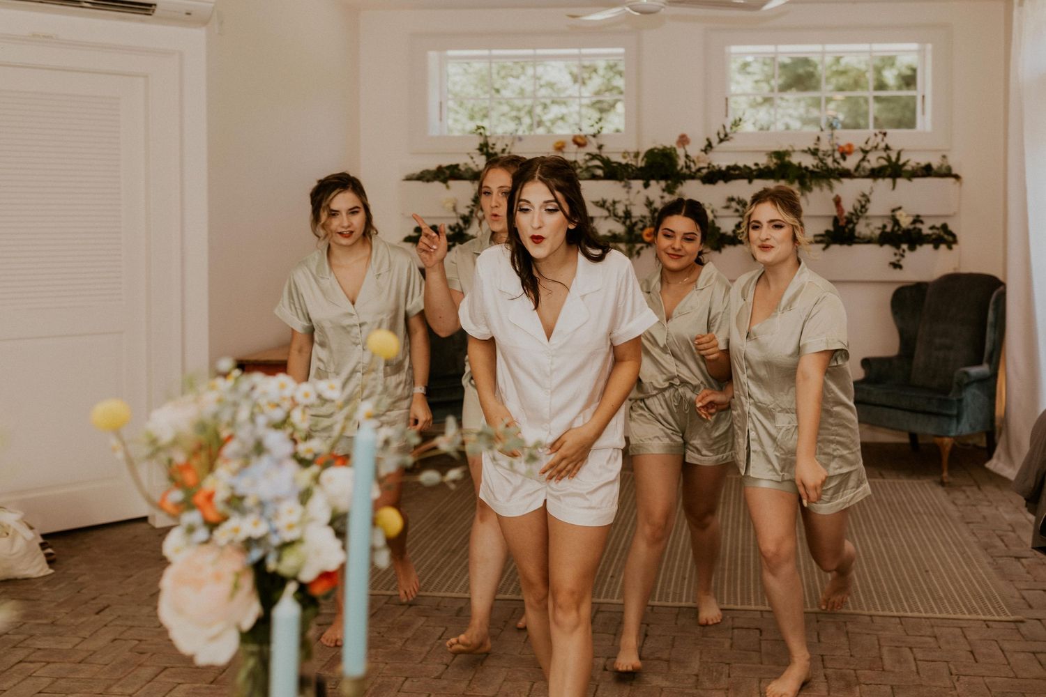Wedding party in matching white outfits posing together.