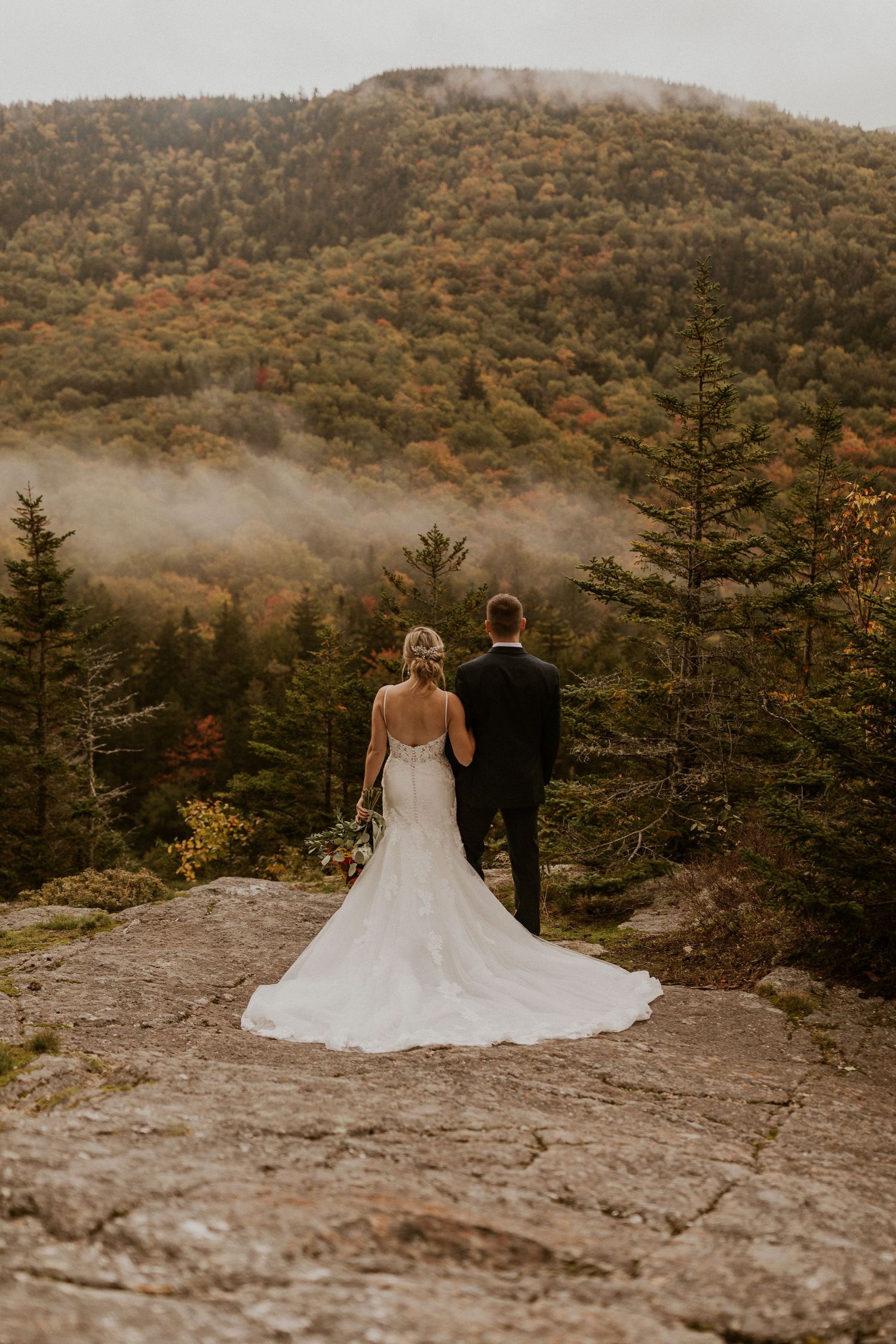 Newlyweds posing for mountaintop portraits in the White Mountain National Forest of New Hampshire.