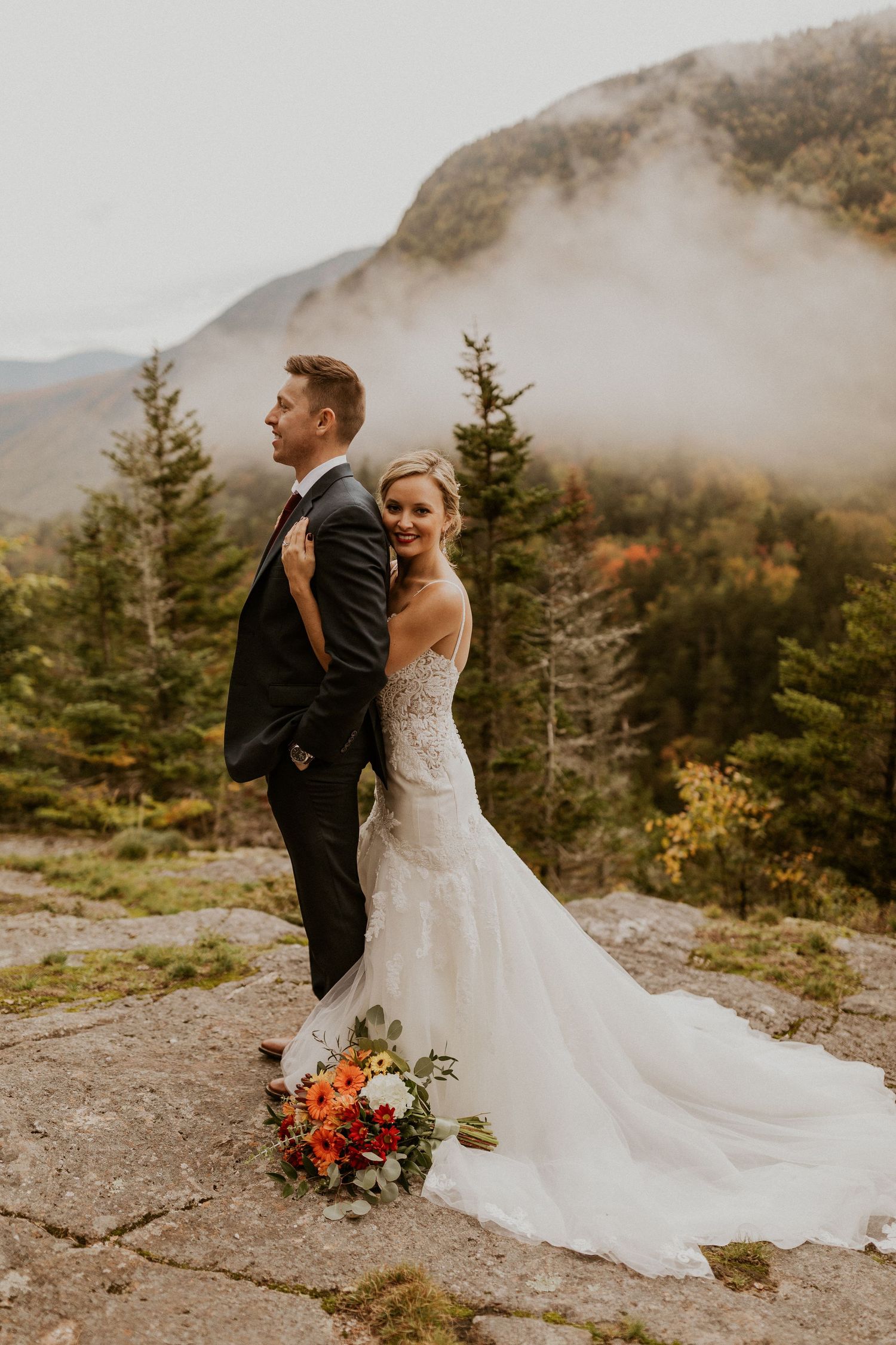 Newlyweds posing for mountaintop portraits in the White Mountain National Forest of New Hampshire.