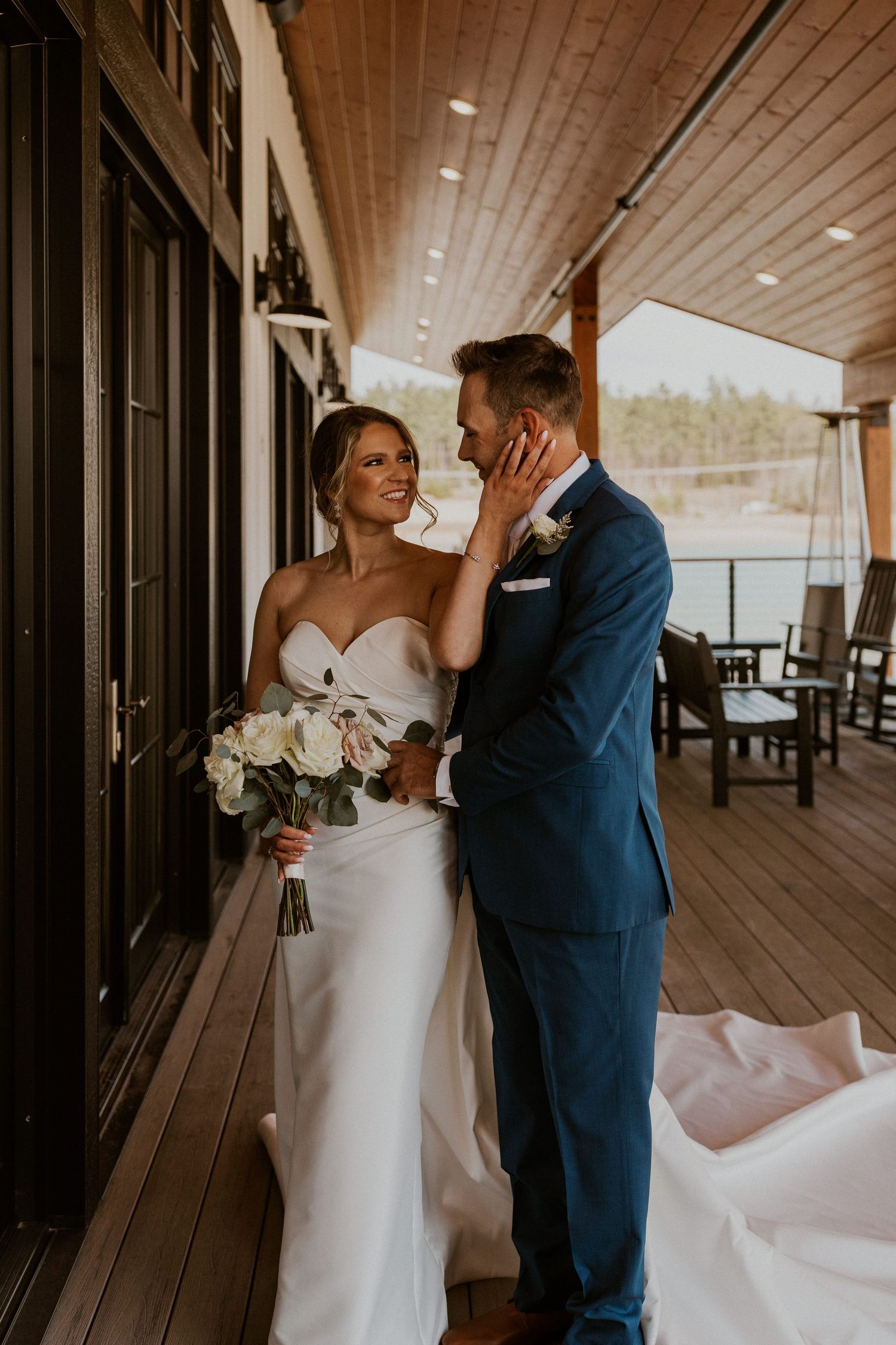 Kendra and Andrew embracing each other lovingly during wedding portraits at the Owl's Nest Lake House in Thornton NH.