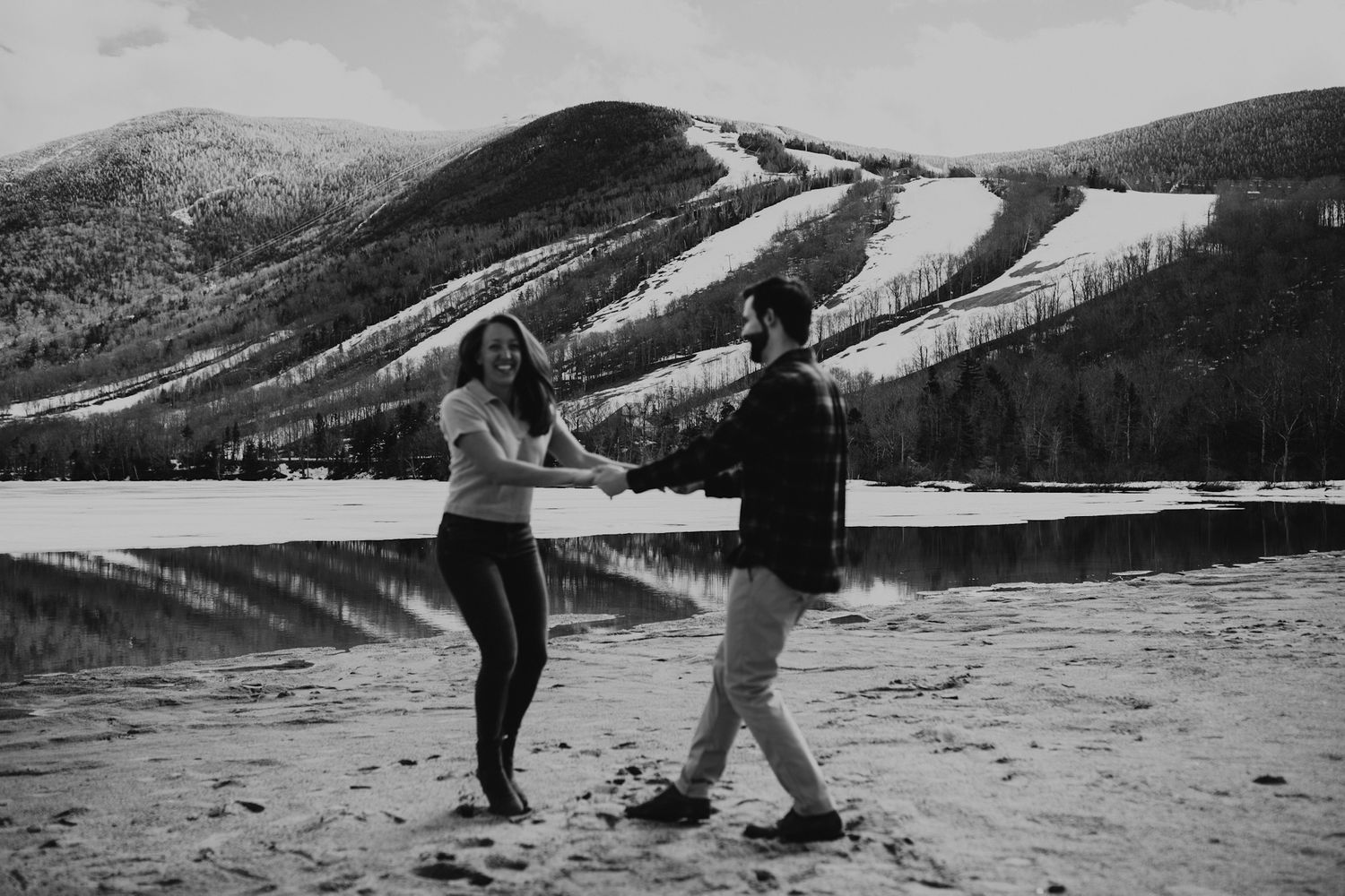 A happy couple dancing in front of Echo Lake in Franconia Notch State Park
