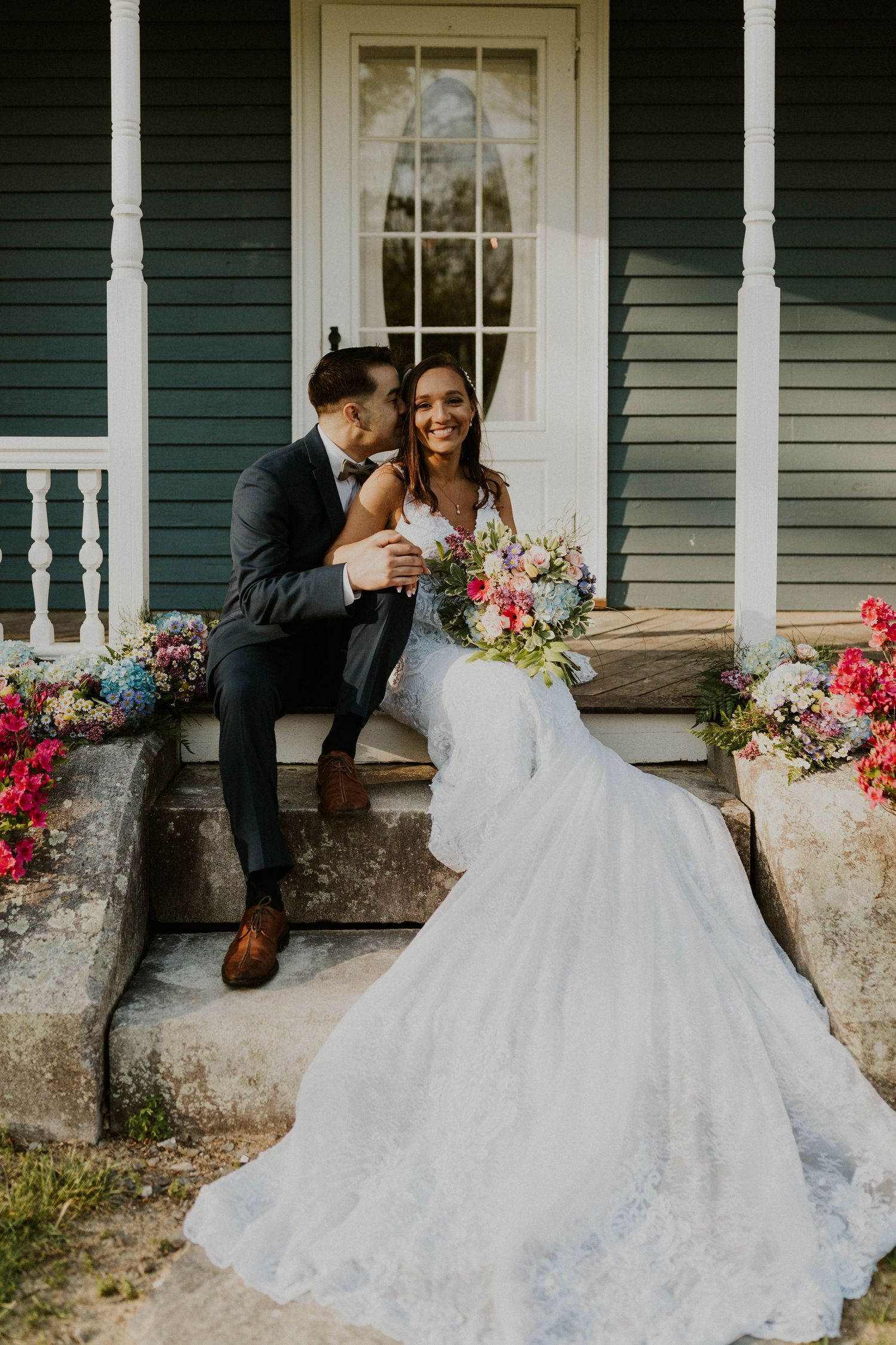 Chrissy and Mike sitting on the front steps of the porch at the Arabella Estate.