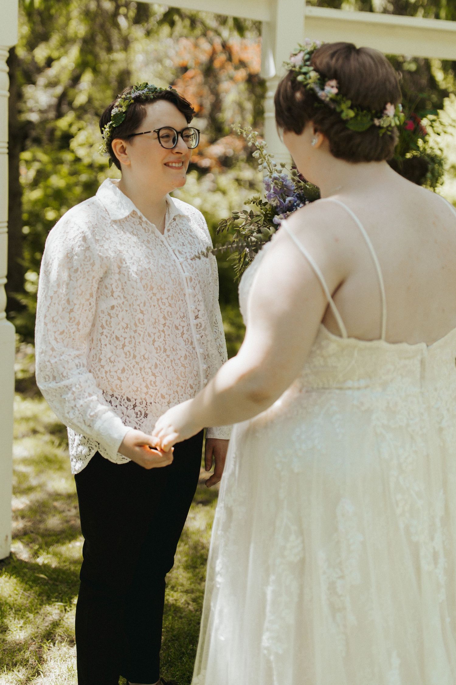 Two people sharing an intimate moment at an outdoor wedding ceremony in lace and formal attire.