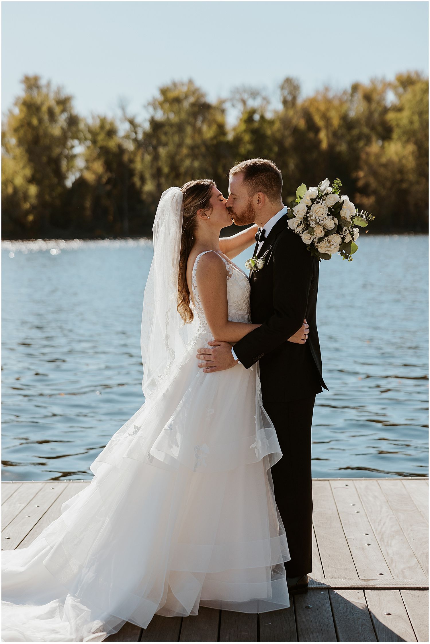 Bride and groom on a dock at their fall New England wedding