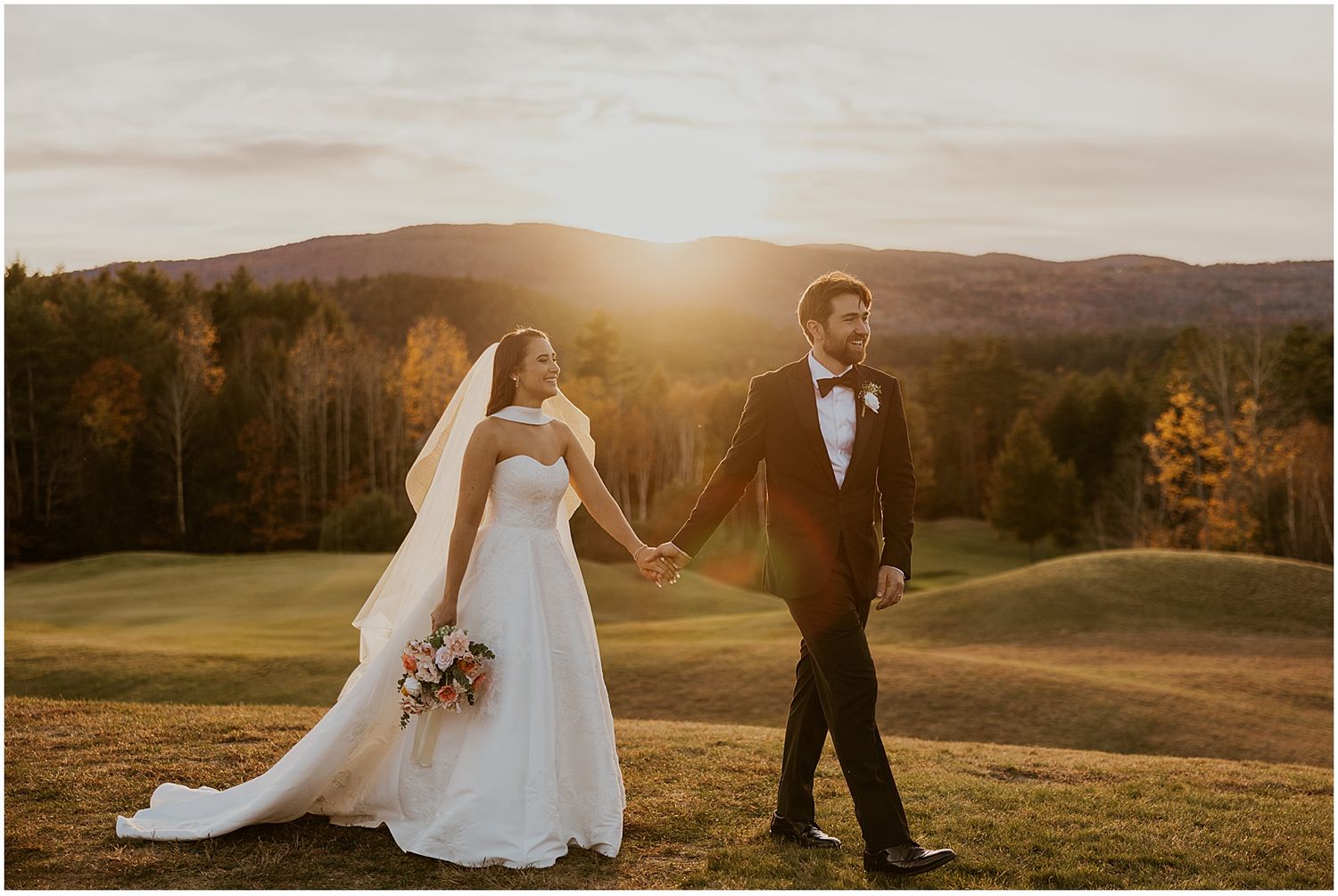 Panoramic wedding photo with mountains and autumn trees in golden evening light.