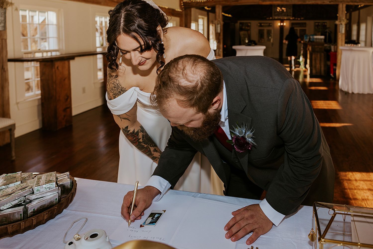 Couple signing their marriage certificate at their NH wedding at the Barn at Powder Major's Farm