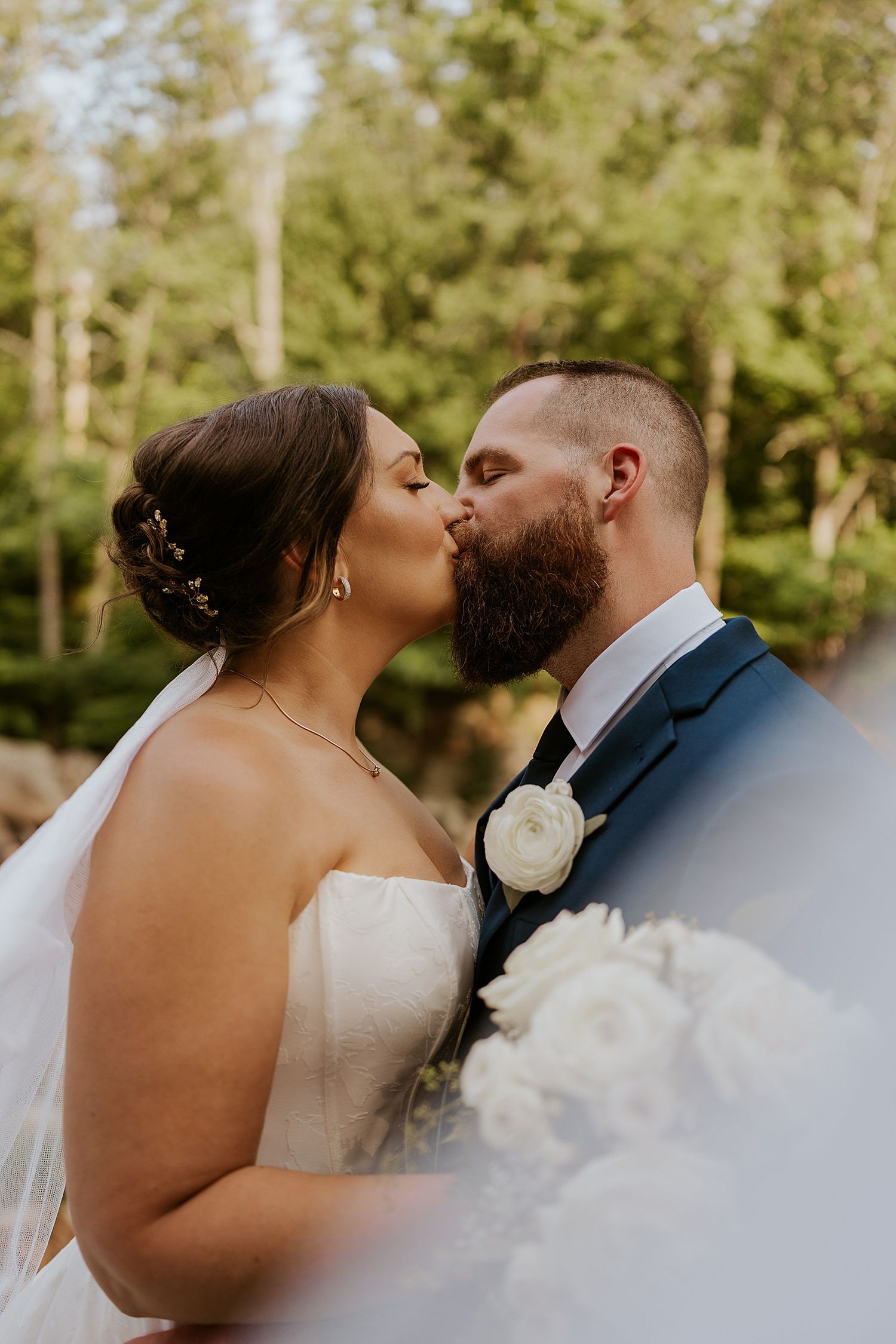 Bride and groom kissing outdoors at their New Hampshire wedding