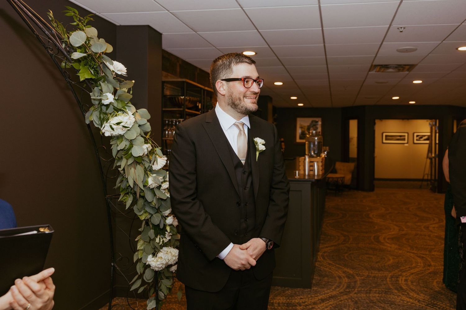 Elegant wedding ceremony setup in a hallway with white floral arrangements and decorative elements.
