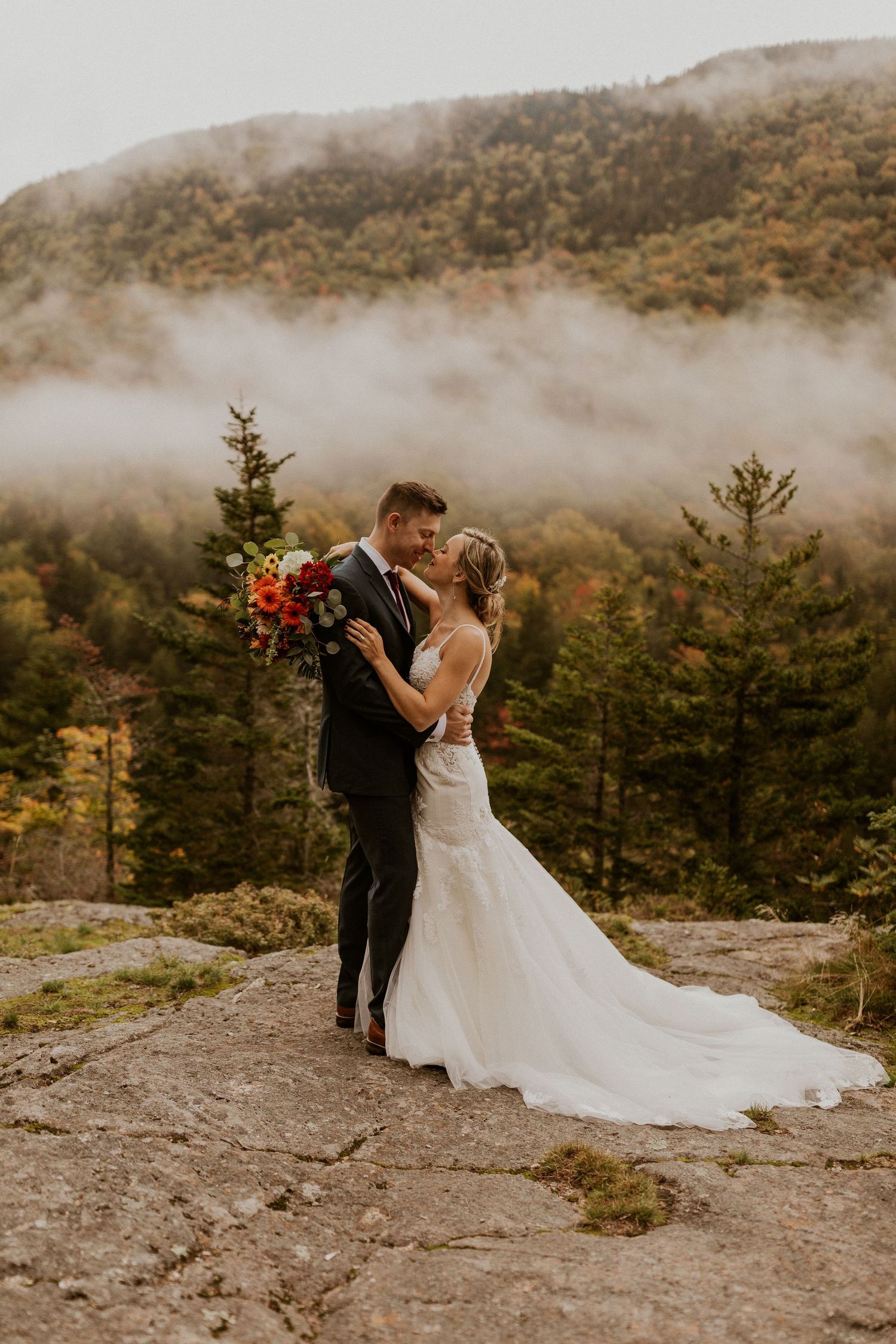 Newlyweds posing for mountaintop portraits in the White Mountain National Forest of New Hampshire.
