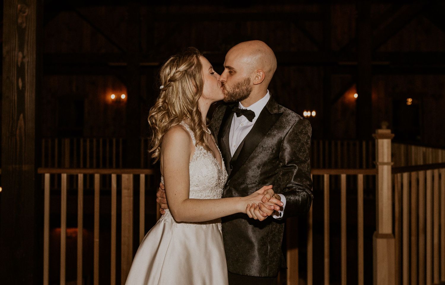 Deirdre and Brodie kissing each other during an intimate moment on the upper level of the venue.