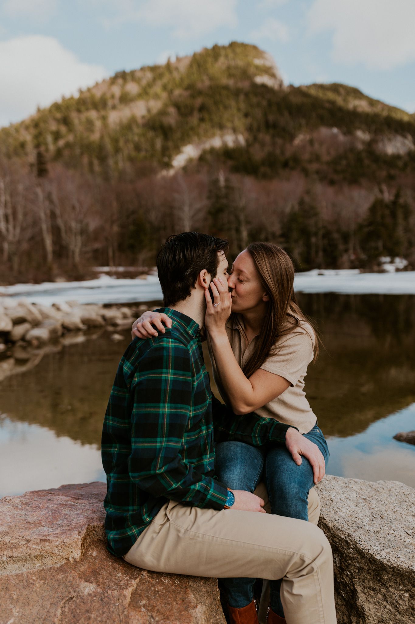 A happy couple standing in front of Echo Lake in Franconia Notch State Park