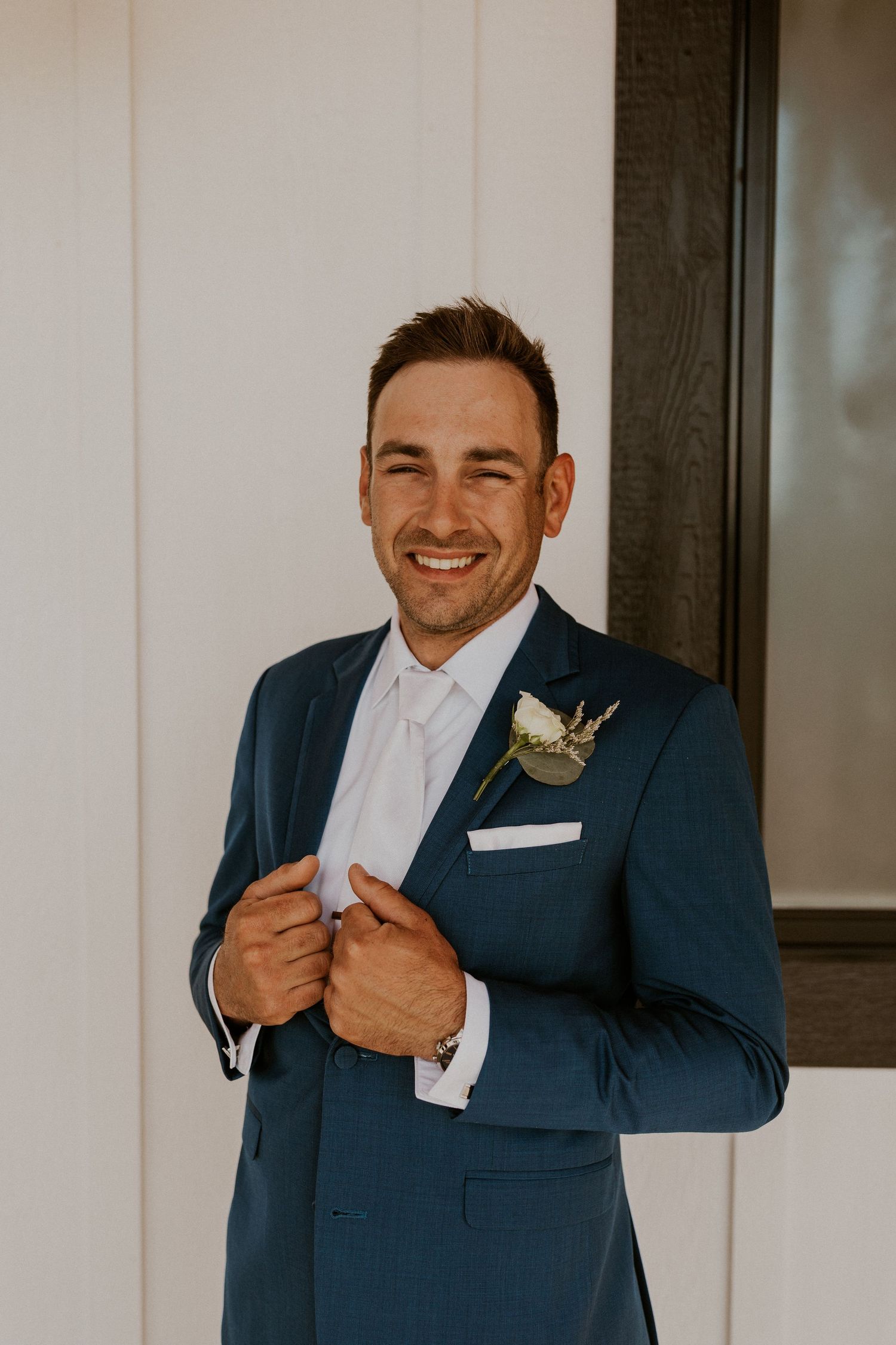 A portrait of the groom on the balcony of the Lake House at Owl's Nest Resort in Thornton New Hampshire