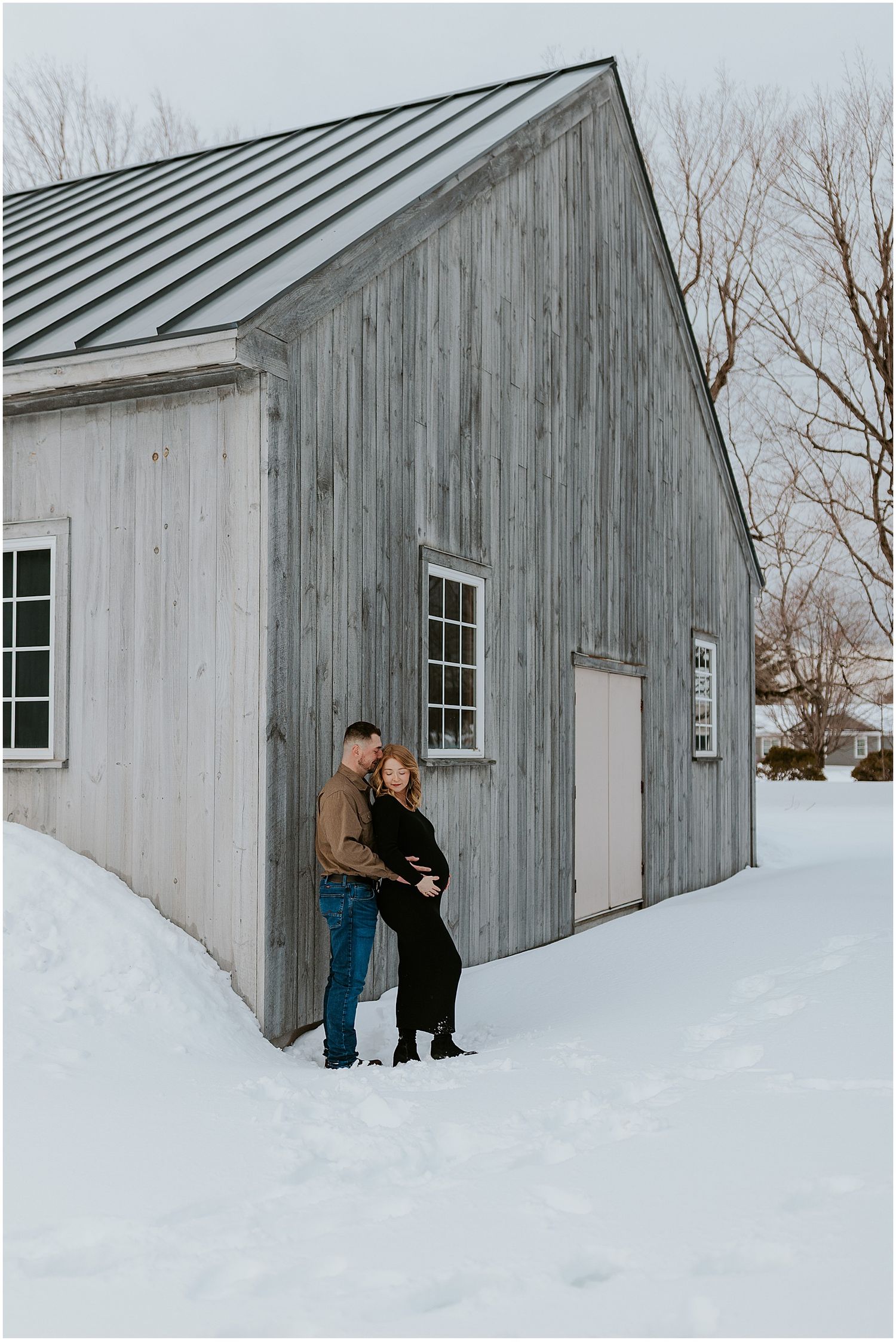 NH couple taking maternity photos in the winter on a snowy day