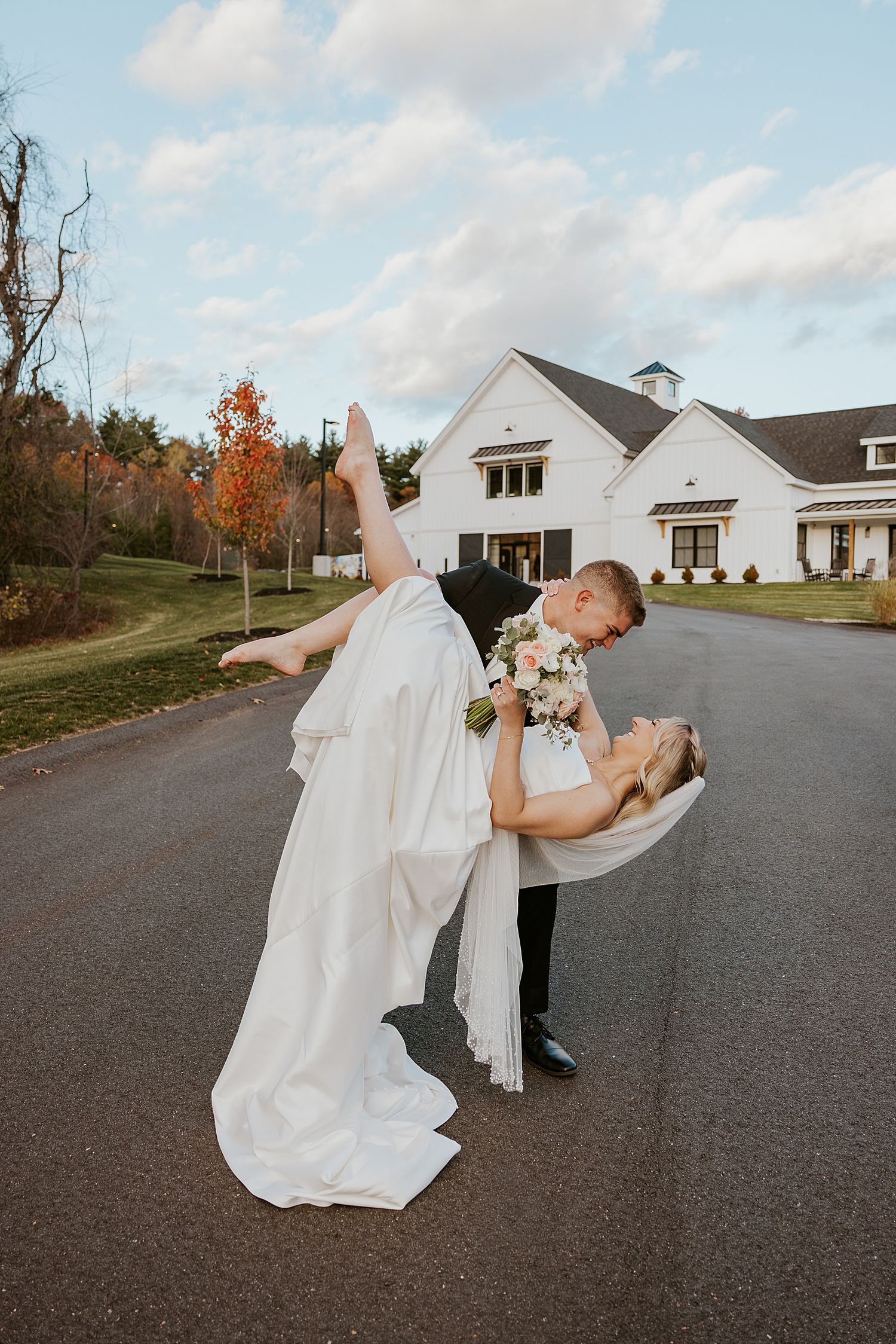 Groom dipping his bride outside the Hyla Brook Estate wedding venue in New Hampshire