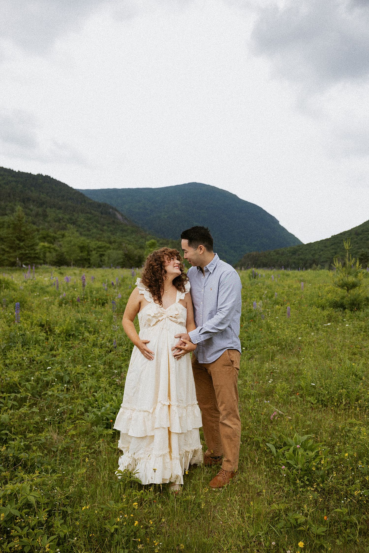 Pregnant New Hampshire couple taking motherhood photos in a field