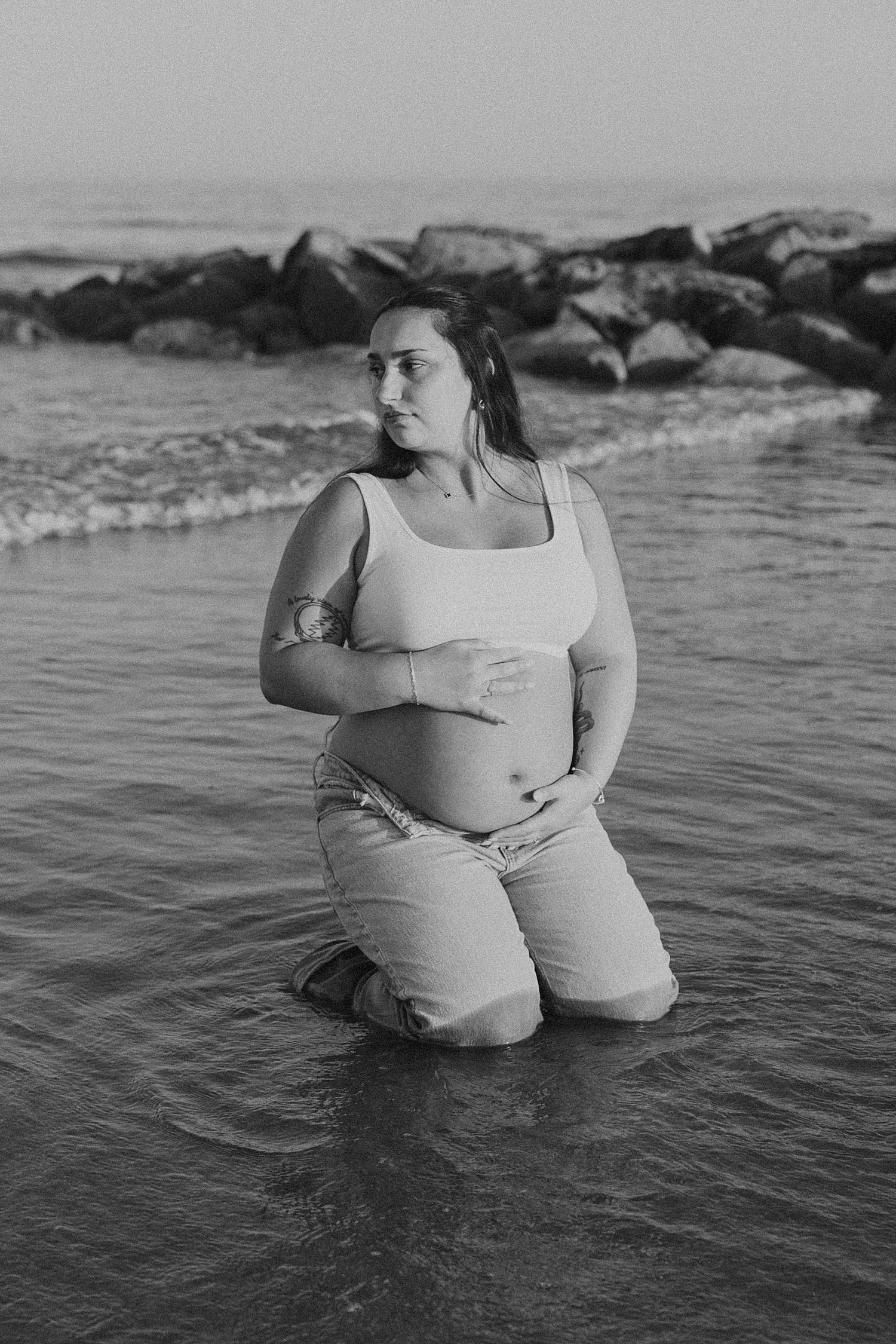 New Hampshire woman taking maternity photos at the beach in the water