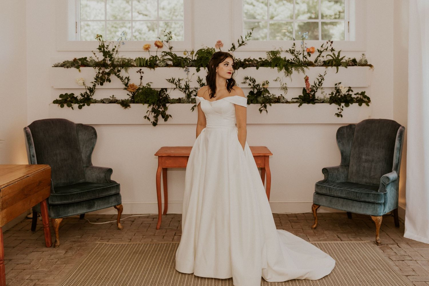 Wedding celebration in a bright indoor venue with vintage furniture and floral garland decorations.