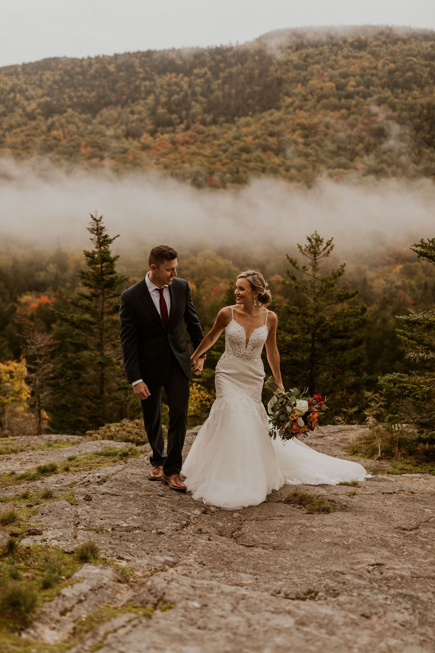 Newlyweds posing for mountaintop portraits in the White Mountain National Forest of New Hampshire.
