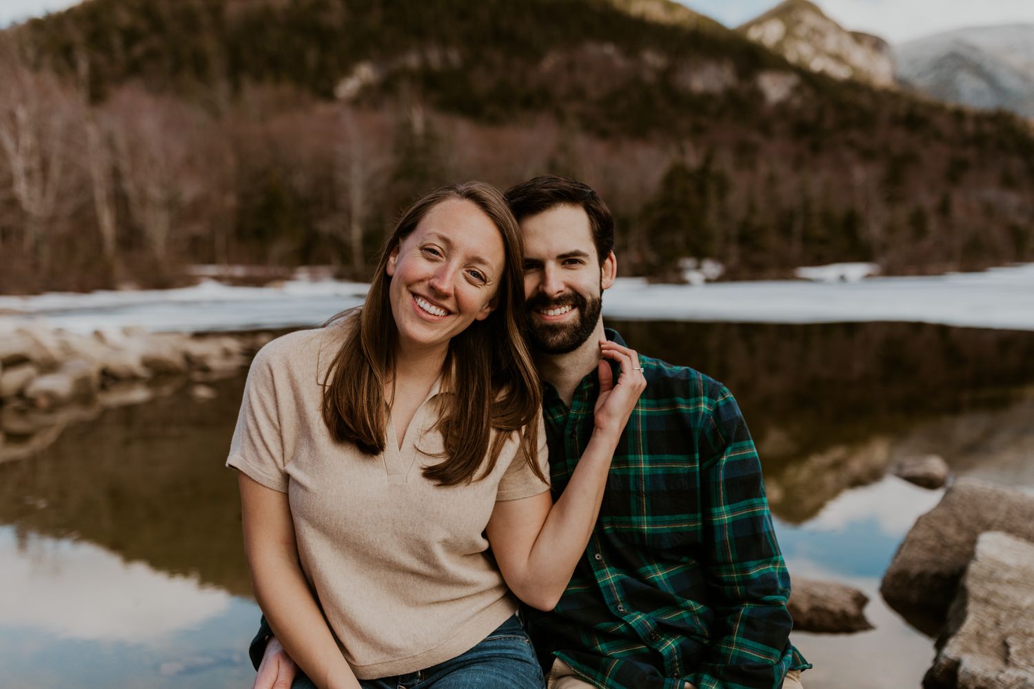 A happy couple standing in front of Echo Lake in Franconia Notch State Park